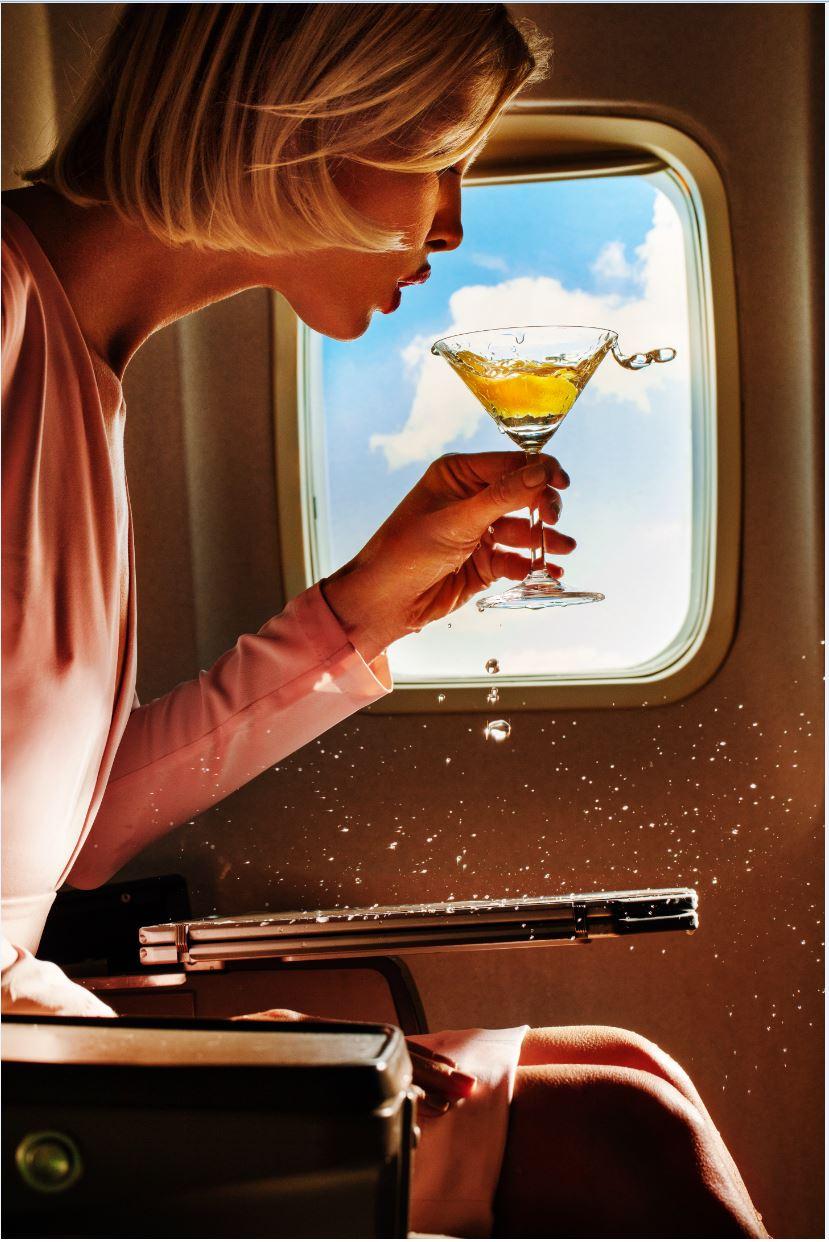 Tony Kelly Figurative Photograph – Turbulence – Frau, die Champagner in einem Flugzeug schenkt, Kunstfotografie, 2019