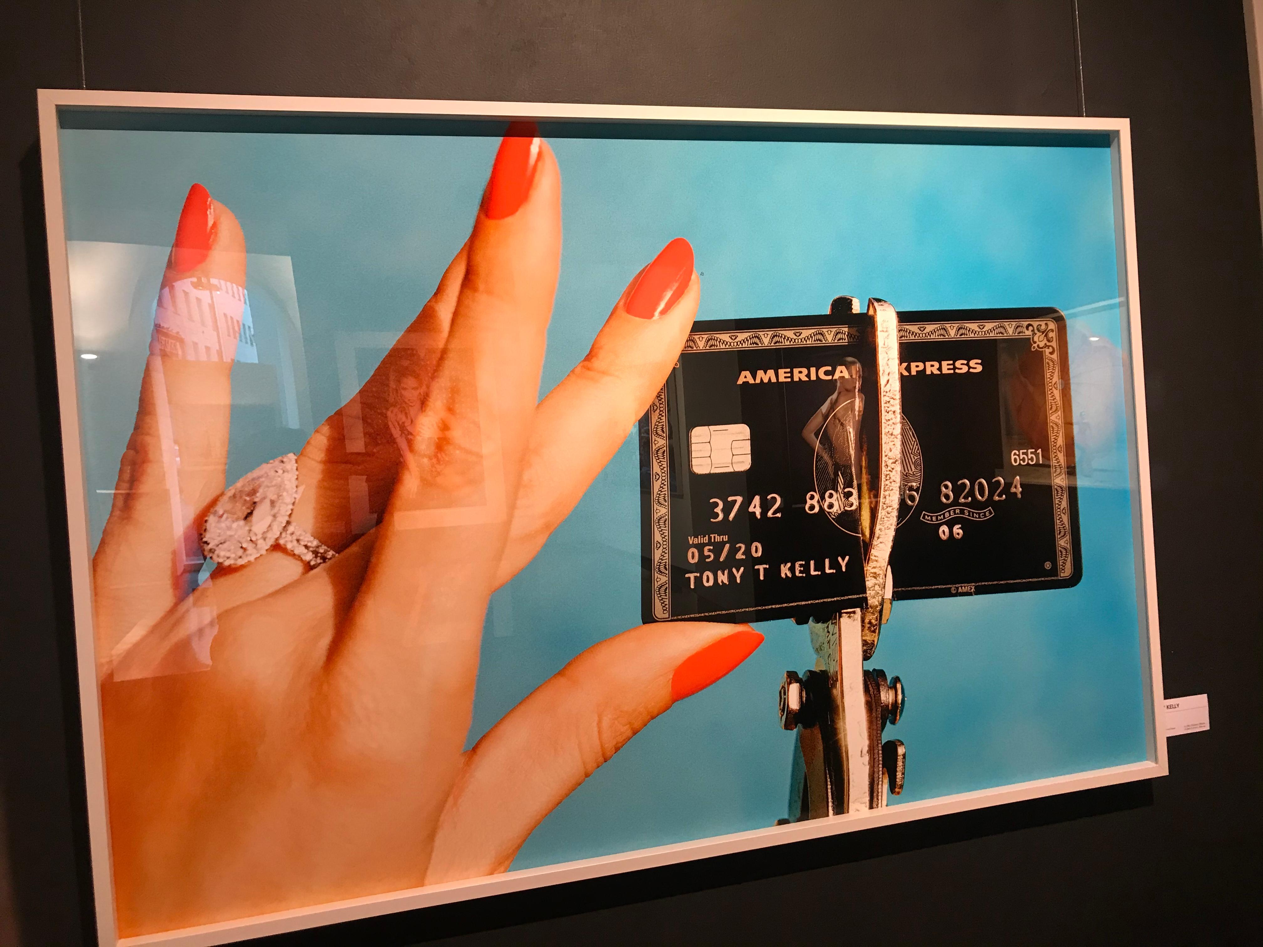 Unbreakable - portrait of hand with red fingernails destroying a credit card - Photograph by Tony Kelly