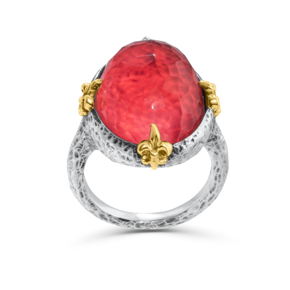 This unique fashion ring is crafted with exquisite attention to detail. The gemstone is a doublet of vivid red coral and highly faceted clear quartz,  set in a handmade sterling silver setting with 18k yellow gold accents. 