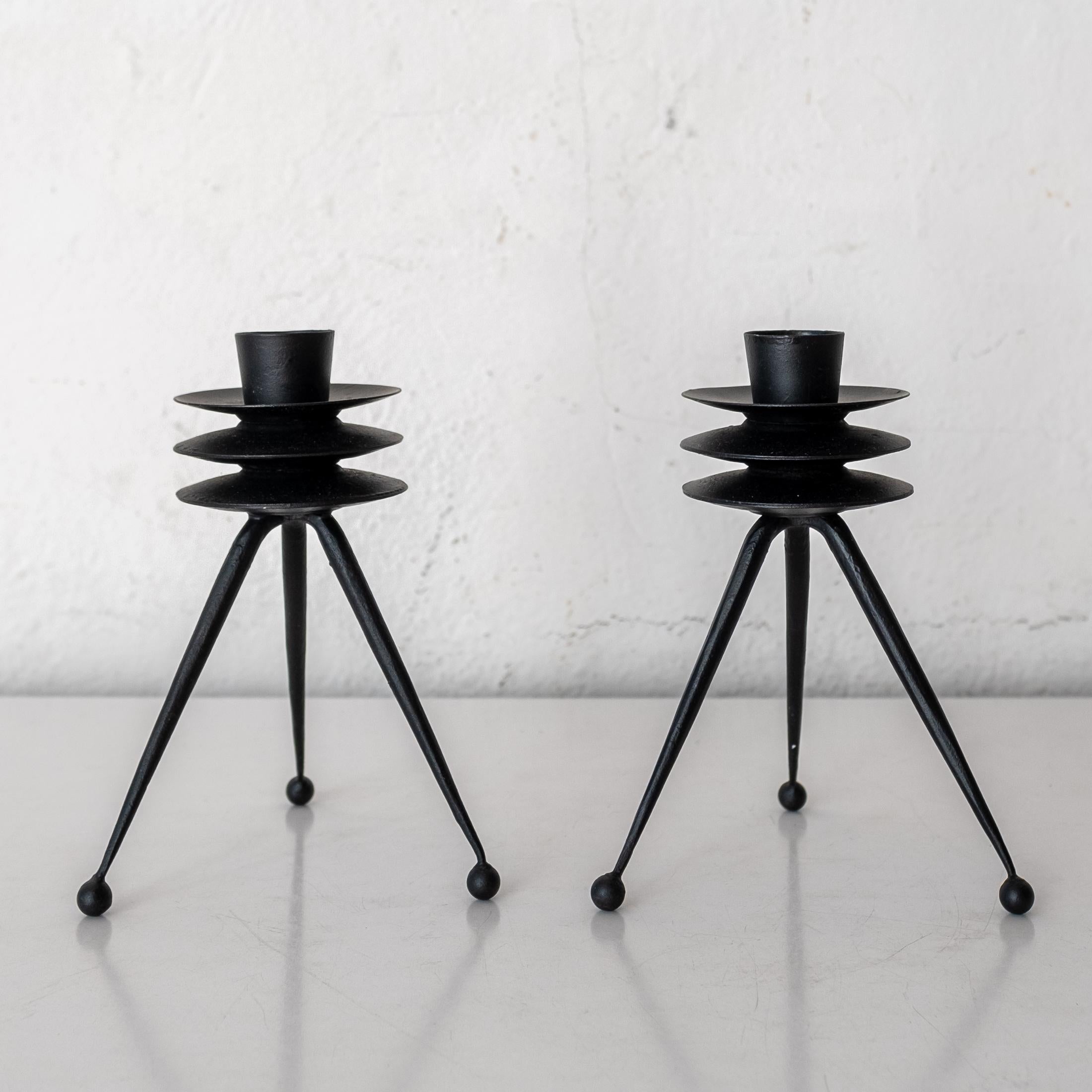 A pair of Tony Paul atomic tripod candle sticks. The cup for the candle holder has a metal spike to ensure the candle stays in palace, This set was part of the Tony Paul Woodlin Hall 