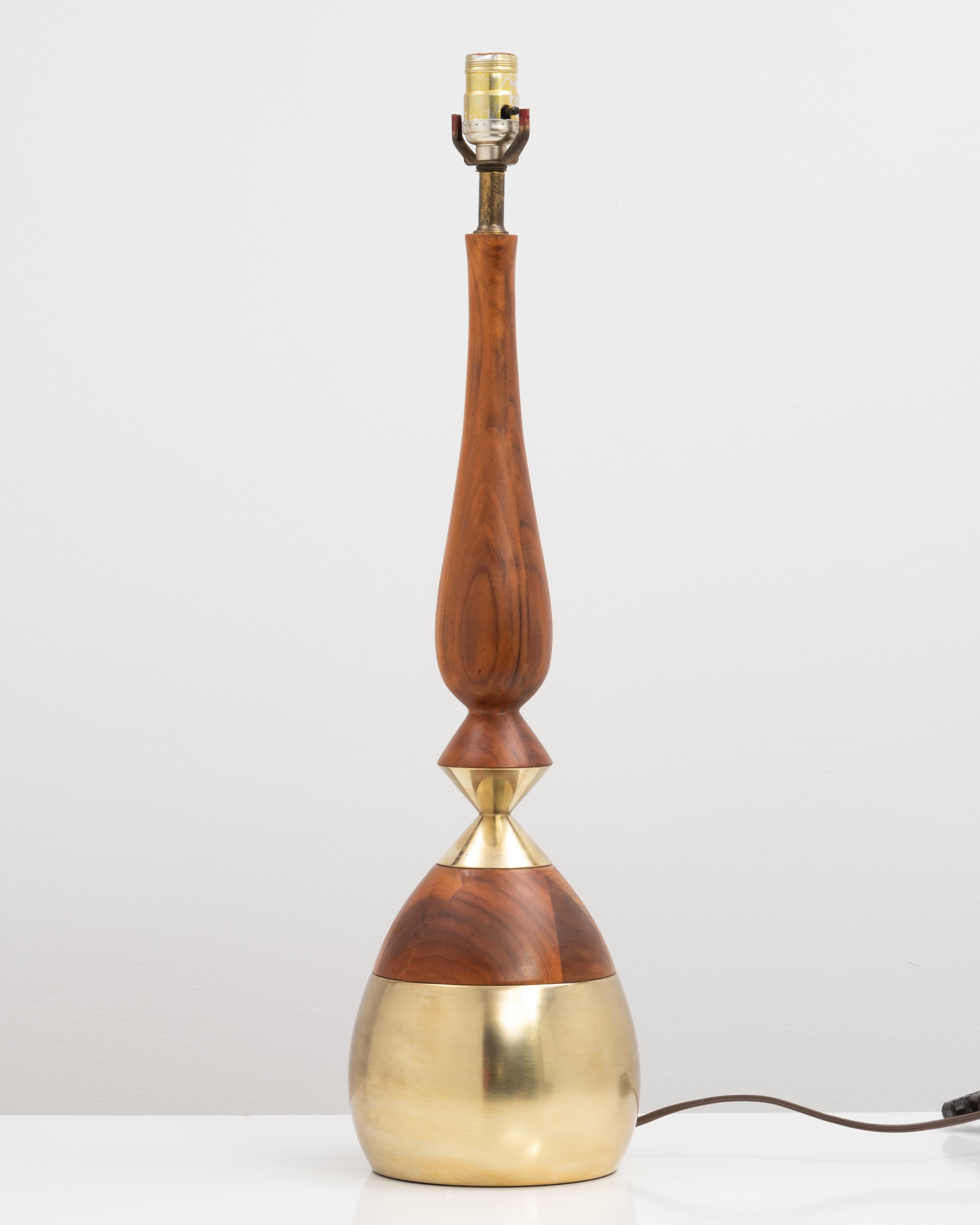 Lampe de table unique conçue par Tony Paul pour Westwood Industries, vers les années 1950. La lampe de forme organique a un corps en bois de noyer avec des détails en laiton poli sur la base et le milieu. Non marqué...