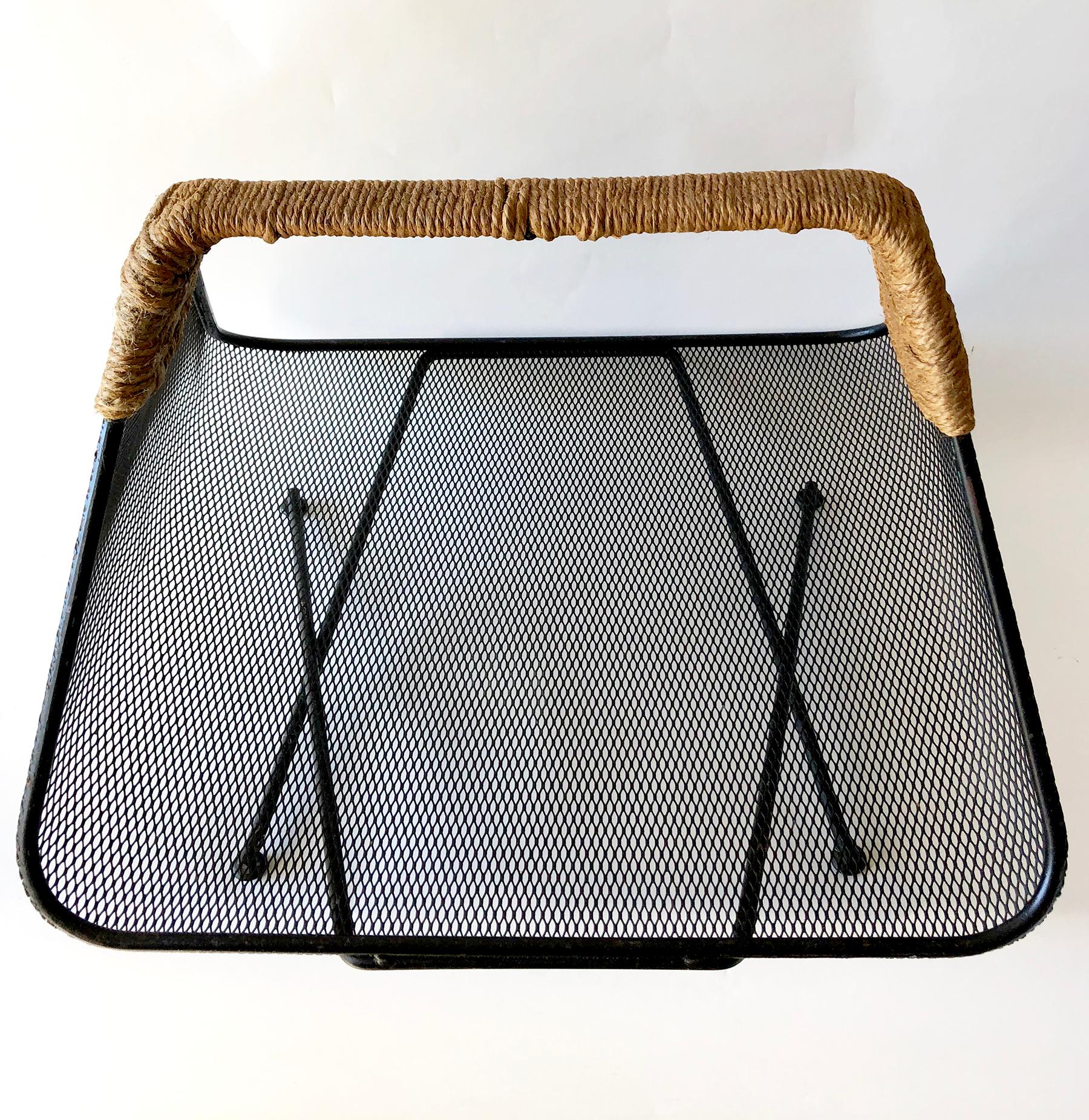 Iron mesh with rush wrapped handle by Tony Paul for Woodlin-Hall magazine rack or log holder, circa 1950's. Measures 15