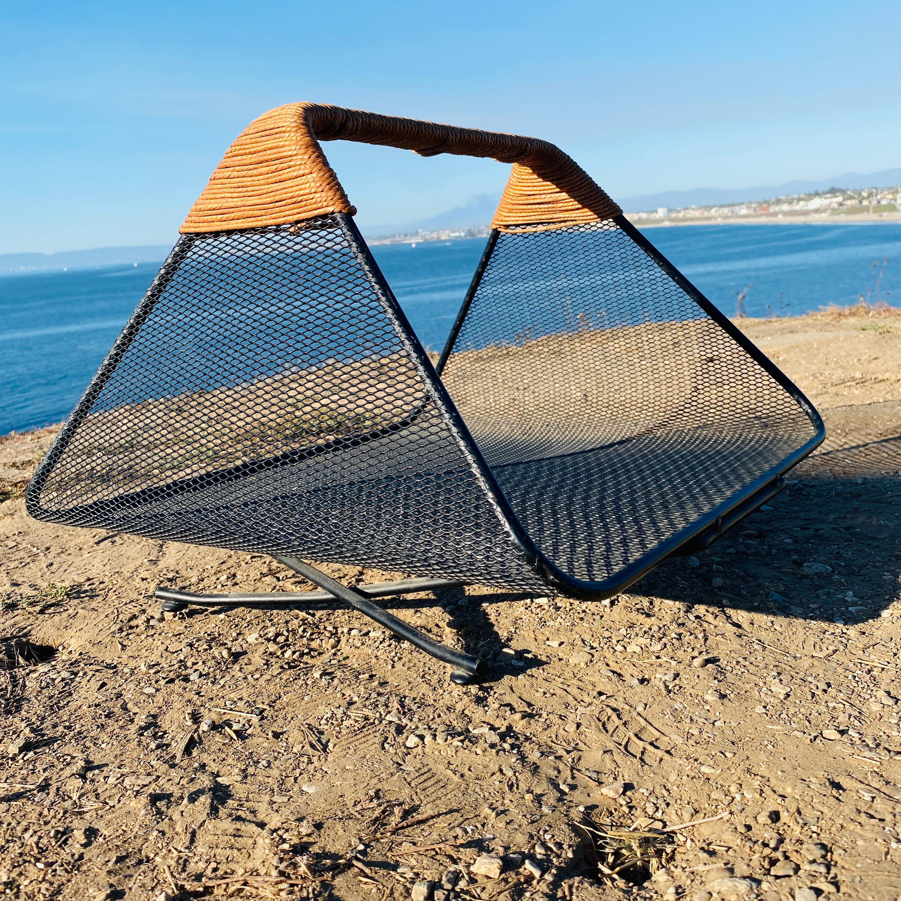 Iconic iron mesh with rush wrapped handle magazine rack or log holder designed by Tony Paul, circa 1950s. 