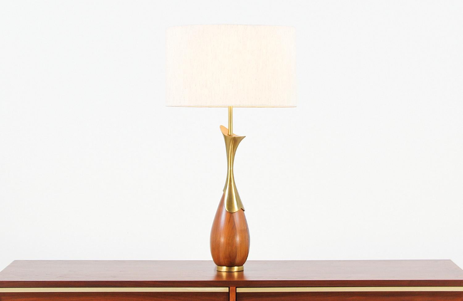 Elegant table lamp designed by Tony Paul for Westwood Industries in the United States, circa 1950s. This lovely large vintage lamp features a walnut wood body with brass detailing for an elegant lighting display. The tear-shaped body sits on a brass