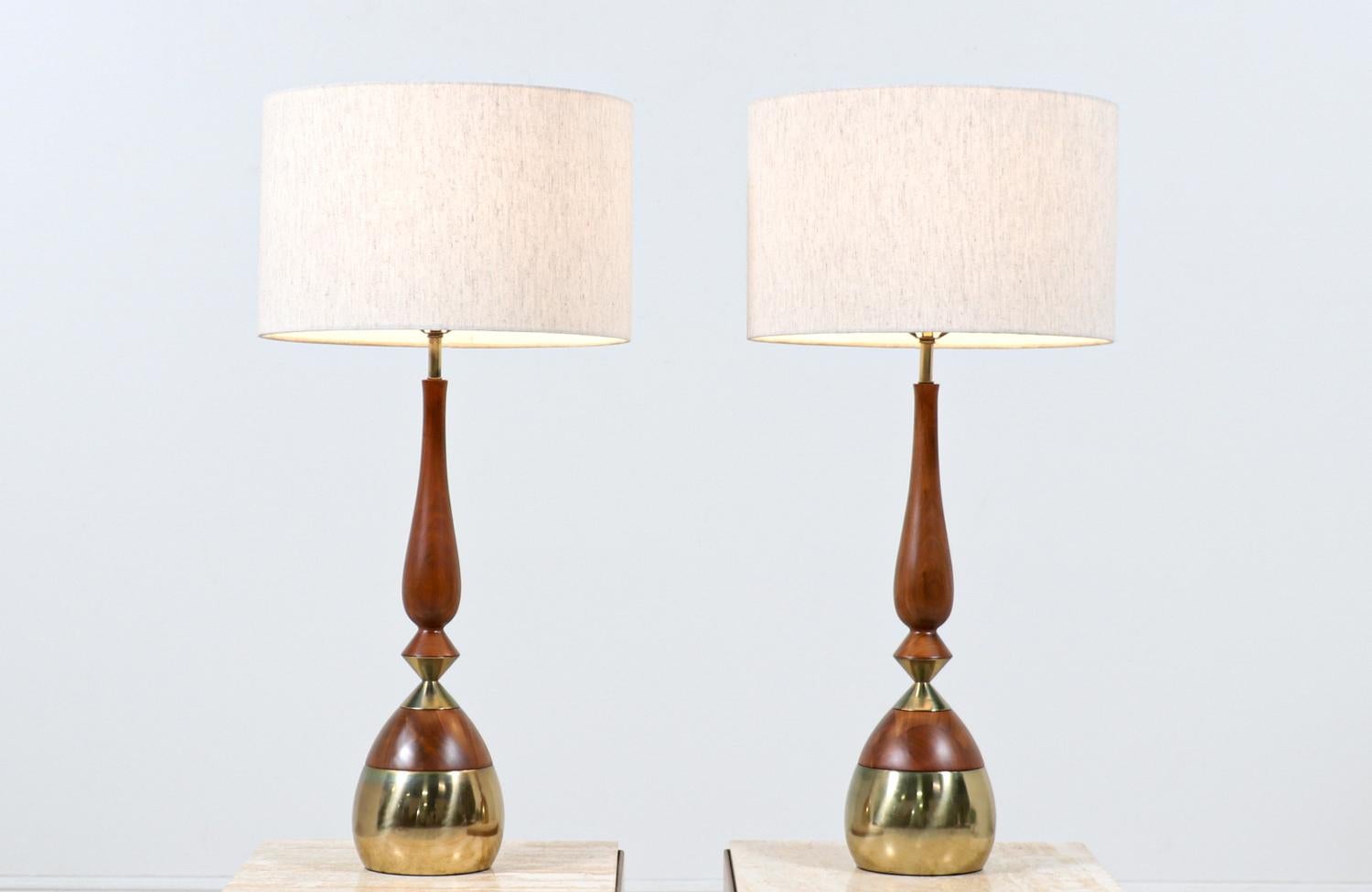 Paire de lampes de table conçues par Tony Paul pour Westwood Industries aux États-Unis vers les années 1950. Ces lampes de forme organique présentent un corps en bois de noyer avec des détails en laiton poli sur la base et le milieu, créant un