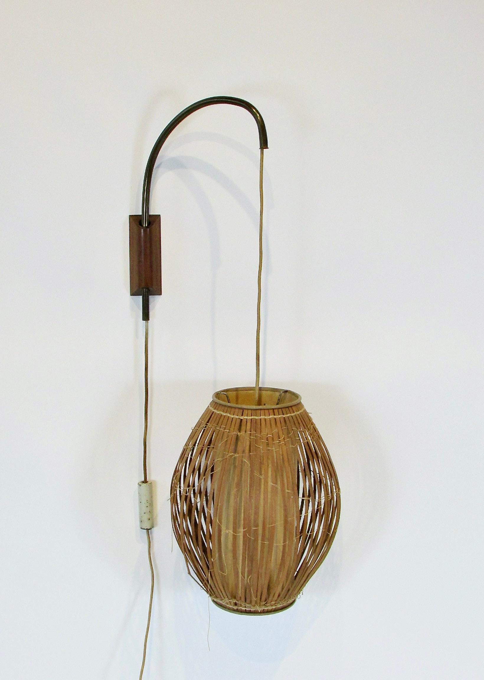 Early piece of mid century design . Adjustable height fish trap style wall mount lamp on swing arm . height is adjusted with counter weight on the cord . Original cloth electric cord . Original thread through the wood slats . 