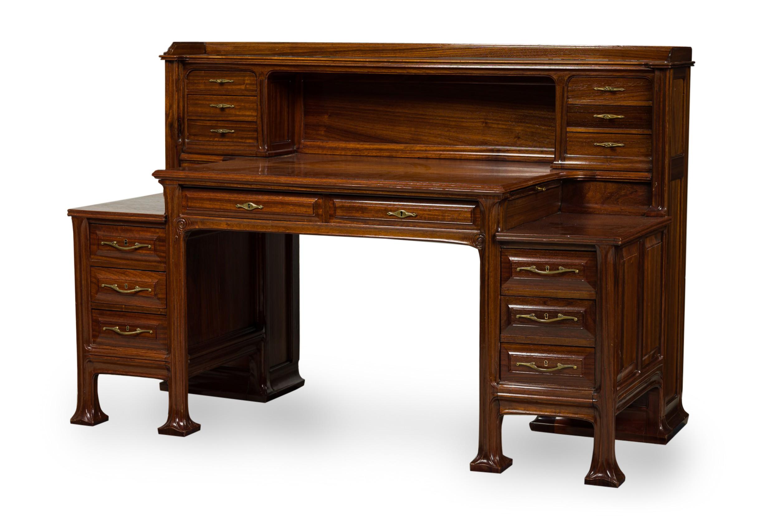 French Art Nouveau mahogany architect\'s desk featuring an upper section of three small drawers with shaped brass pulls on either side of an open compartment, above a rectangular table top over two drawers perpendicular to two additional pull out
