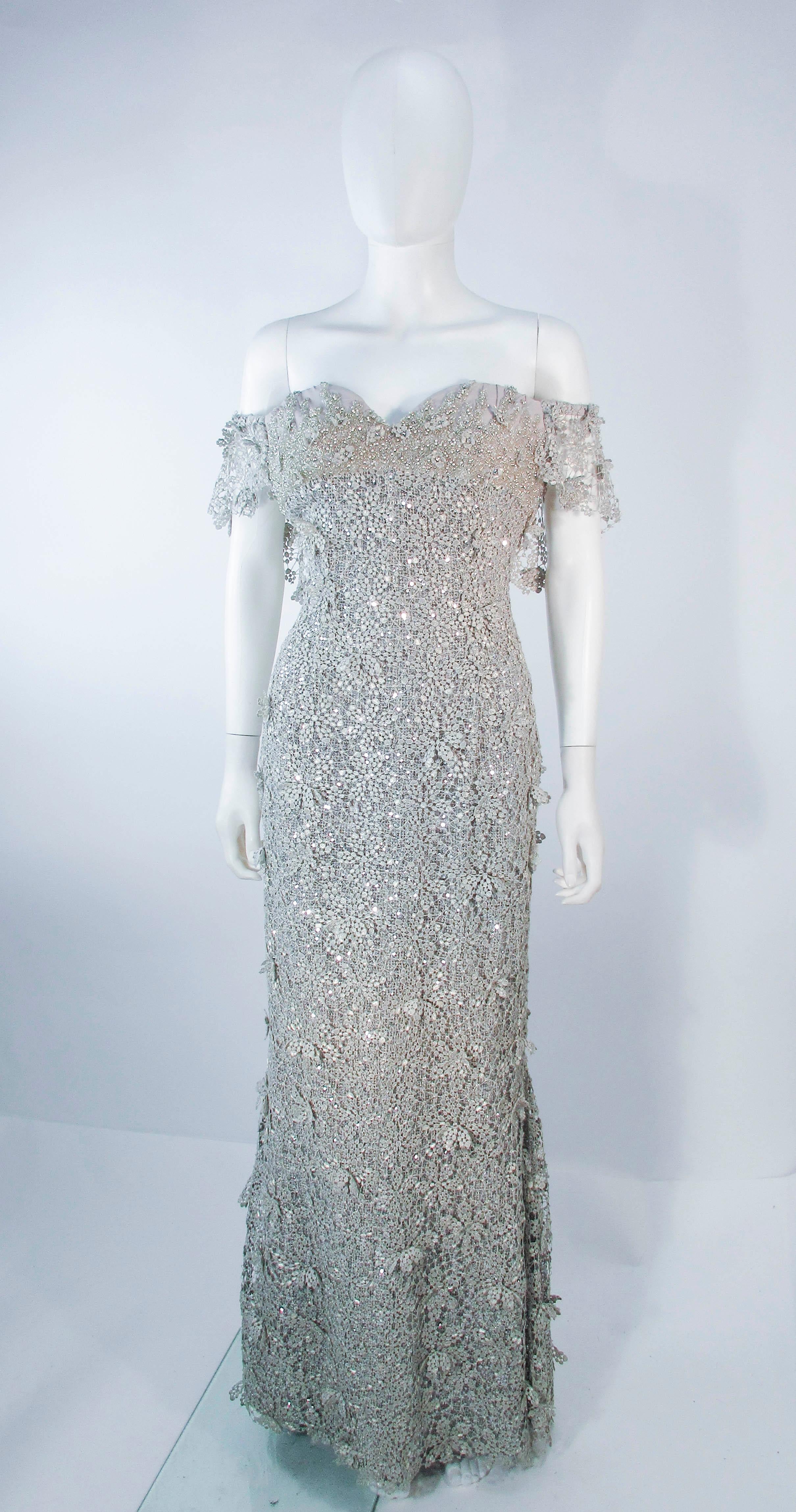 This is a Tony Ward design which is composed of a silver-tone gold metallic lace. Features and off the shoulder style, and sweetheart bust detail. There is a zipper closure. In excellent pre-owned condition. Please feel free to ask us any additional