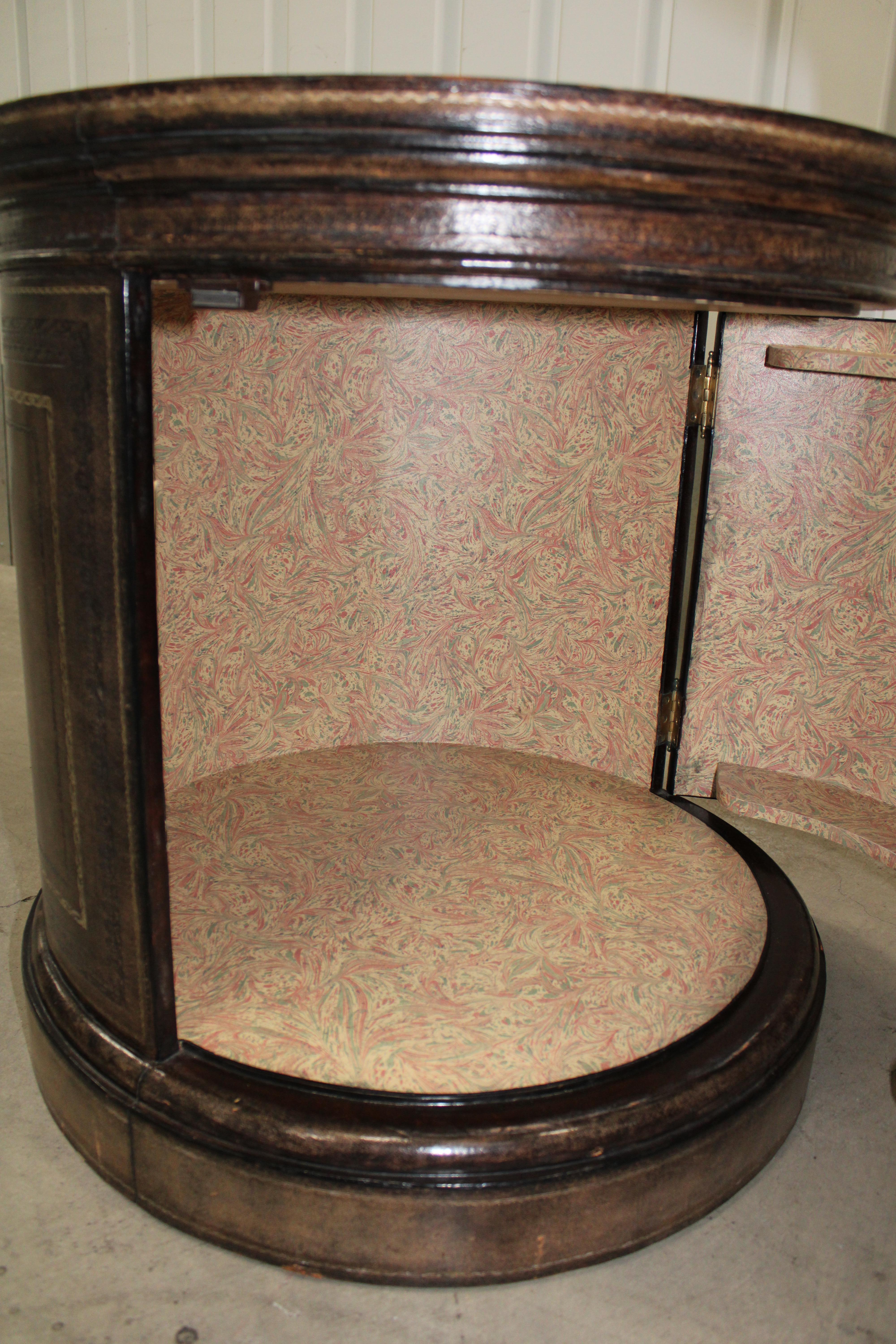 C. 20th century

Tooled leather drum side table w/ cabinet (Marbleized Paper Interior).