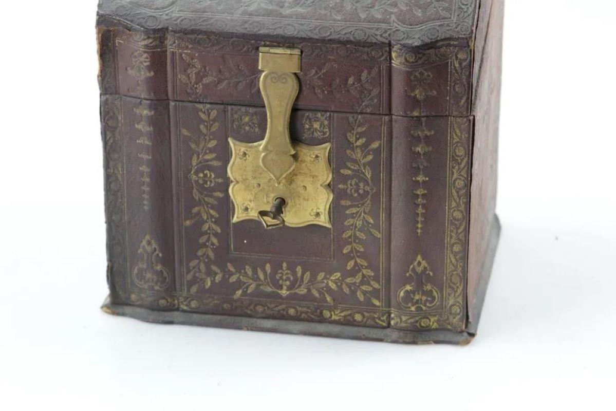 A French tooled leather letter box with brass handle and lock, retaining its original key, the interior lined with green silk fabric, late 18th century.