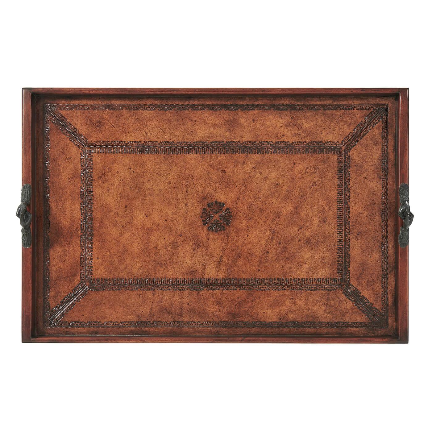 An English style brown tooled leather covered tray of rectangular shape with gallery and brass handles of clasping hands. 

Dimensions: 31.5