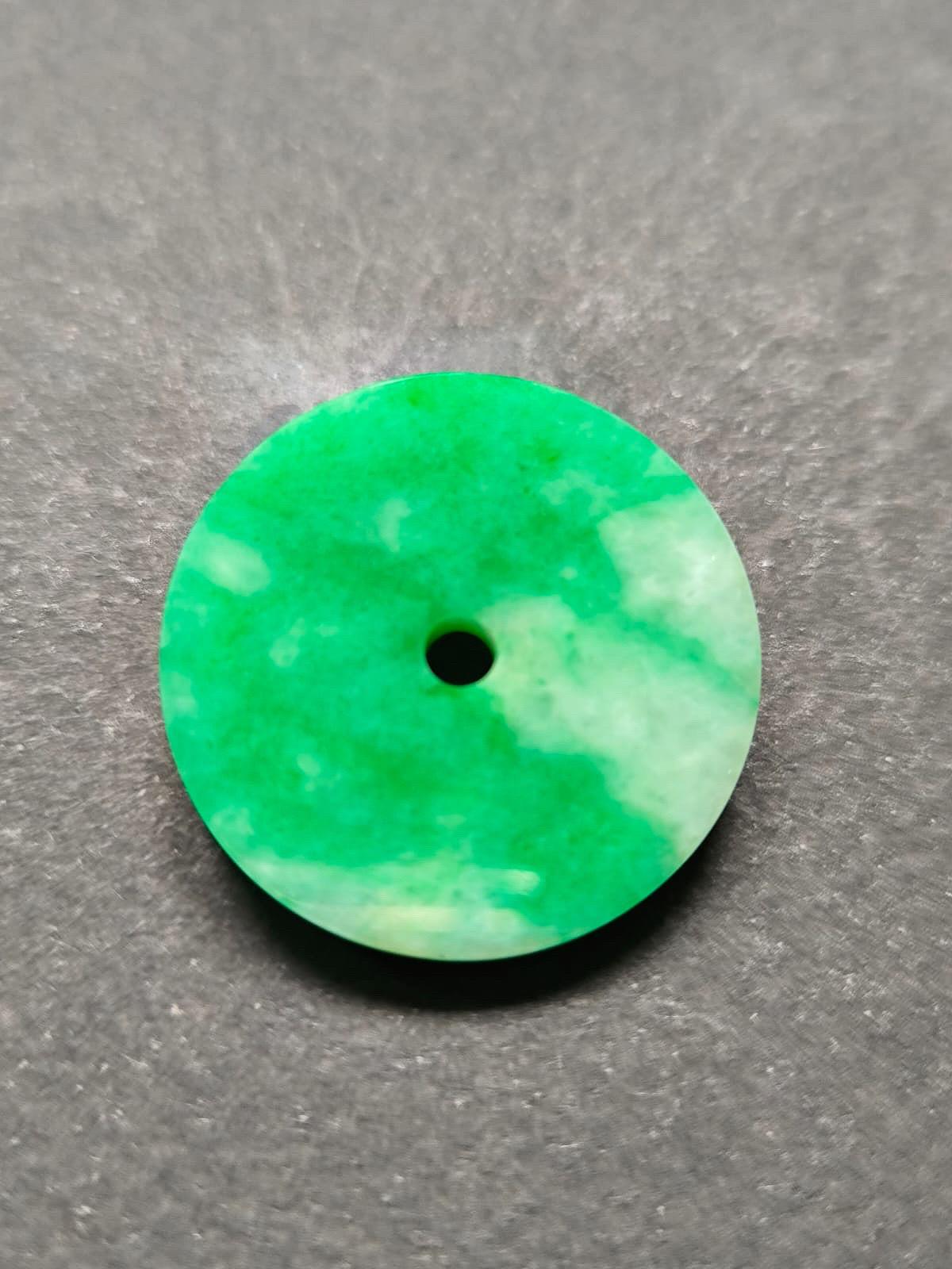 Immerse yourself in the captivating beauty of this stunning natural imperial green jade donut pendant. Crafted from the finest Type-A Myanmar jadeite jade, this pendant is a true masterpiece of nature's artistry.

The jade donut features a