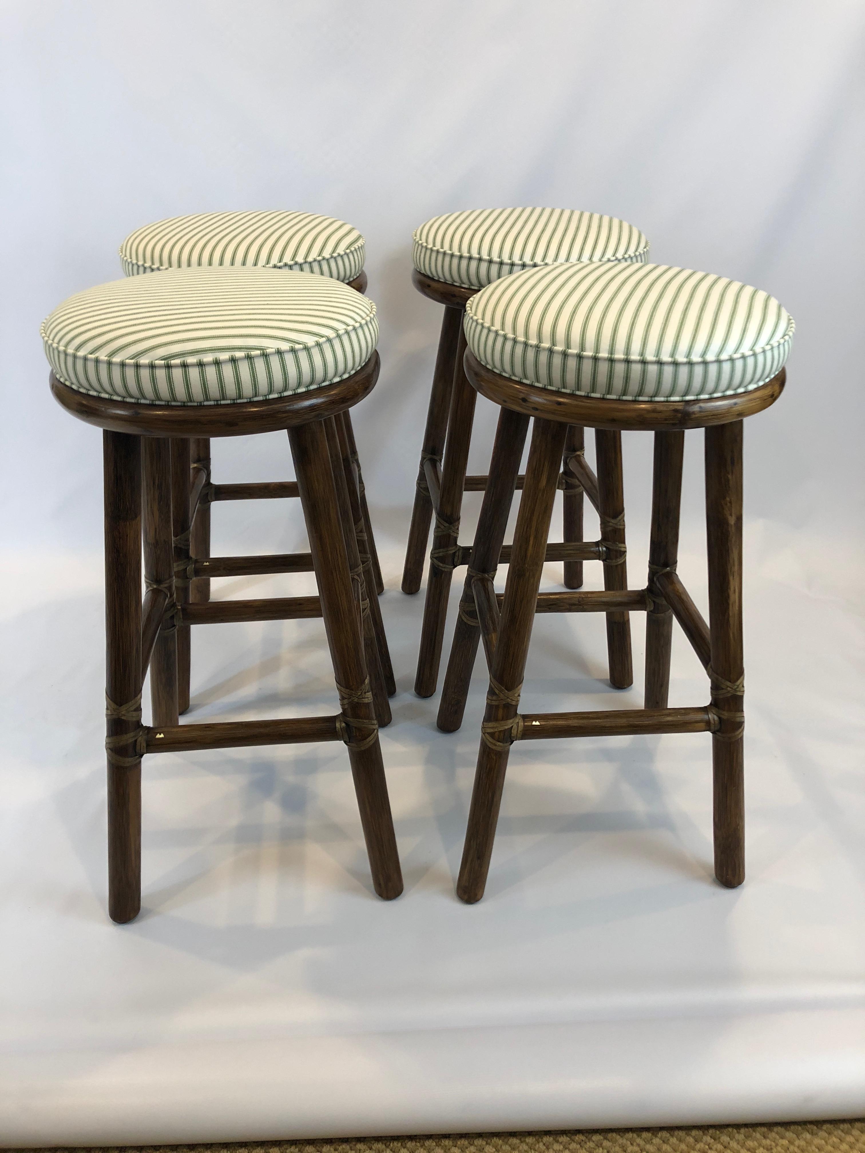Beautifully made as only McGuire does it, a handsome set of 4 substantial tobacco colored bamboo bar stools having leather bindings and attached green and white striped seat cushions.
Bottom is 15.75 square.