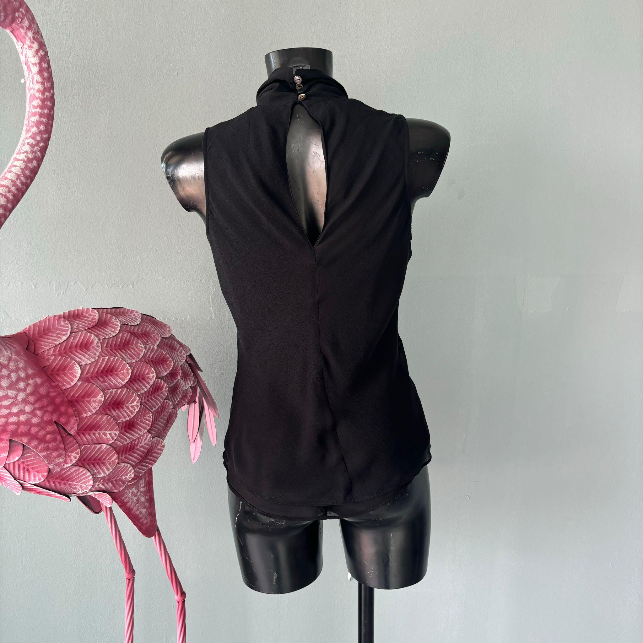 Top smanicato Prada con collo alto e chiusura sul retro
Collo alto e doppio strato
Composizione 100% seta
Misure:
Petto 64cm
Lunghezza 68cm
