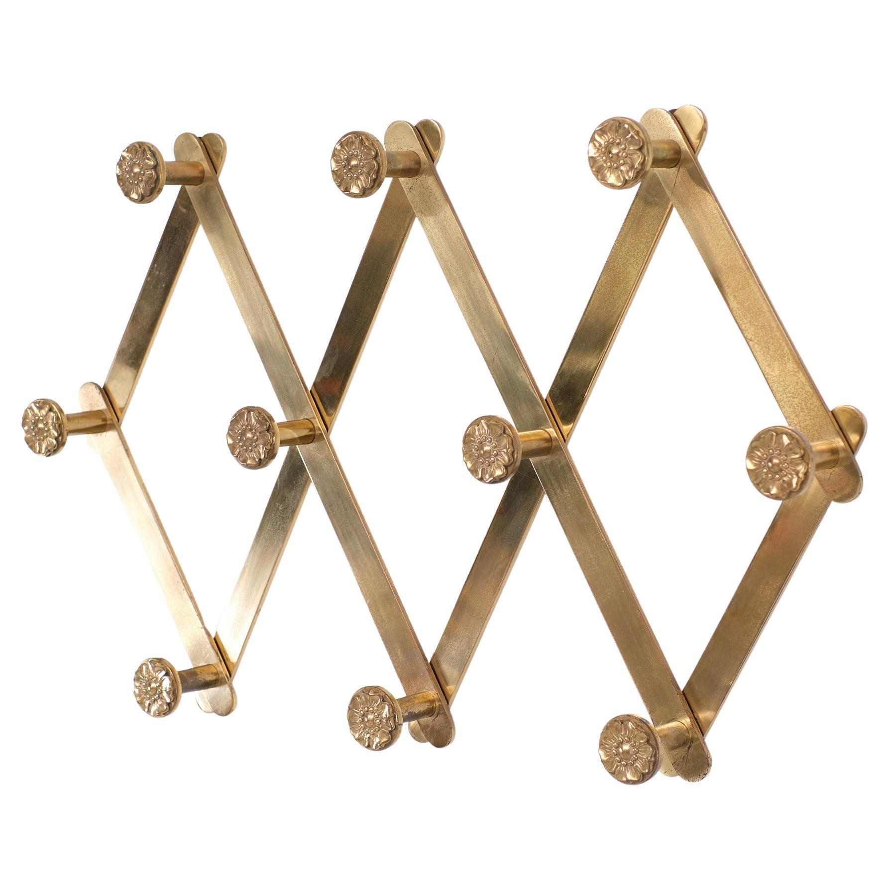 Top quality solid Brass wall coatrack .Harmonica shaped .Adjustable 
in width  . Ten Knobs with decorative Flowers .for your coats .
Very remarkable with this coatrack the original purchase receipt. bought by Warners high end store in The Haque for