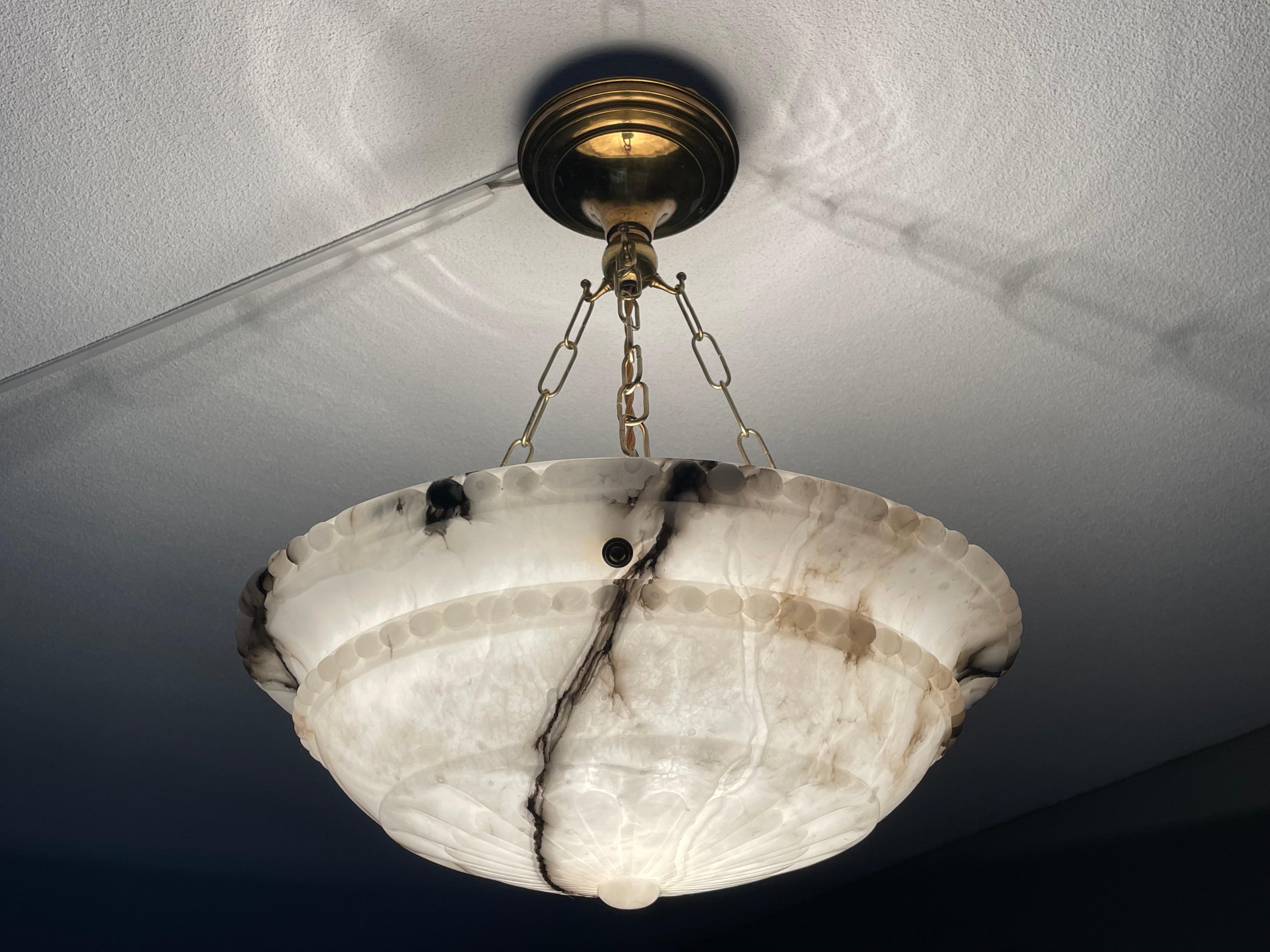 Truly stunning alabaster light fixture.

Thanks to its good side, its stunning alabaster shade and its ideal brass canopy this alabaster pendant light from the European Art Deco era is one of the most beautiful models we have seen and sold. Many of