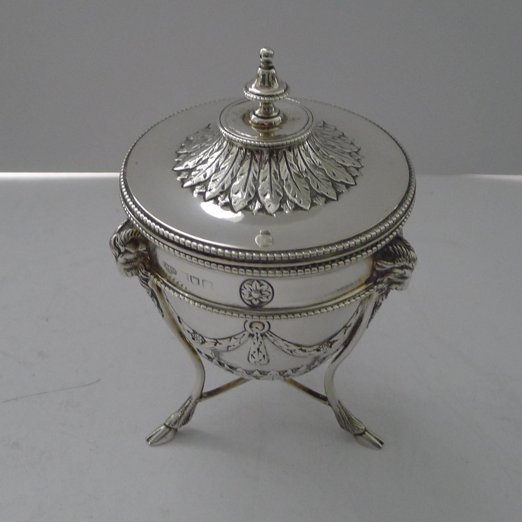 Excepcional caja de té eduardiana de estilo Adam, apoyada sobre tres patas de pezuña y bellamente decorada con tres cabezas de carnero, guirnaldas y hojas de acanto.

La plata tiene el sello de Londres de 1908, es de la época eduardiana y una