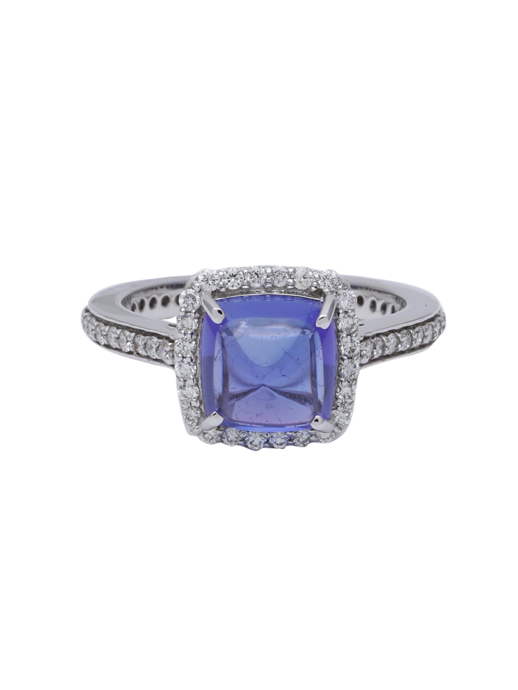 Top Quality Loupe clean Tanzanite Sugarloaf weighing 3.45 carats set with diamonds all around in a halo setting. The ring is beautifully made in 18K White Gold.
The Tanzanite has a really pretty dome and the colour is perfect and pops out on the