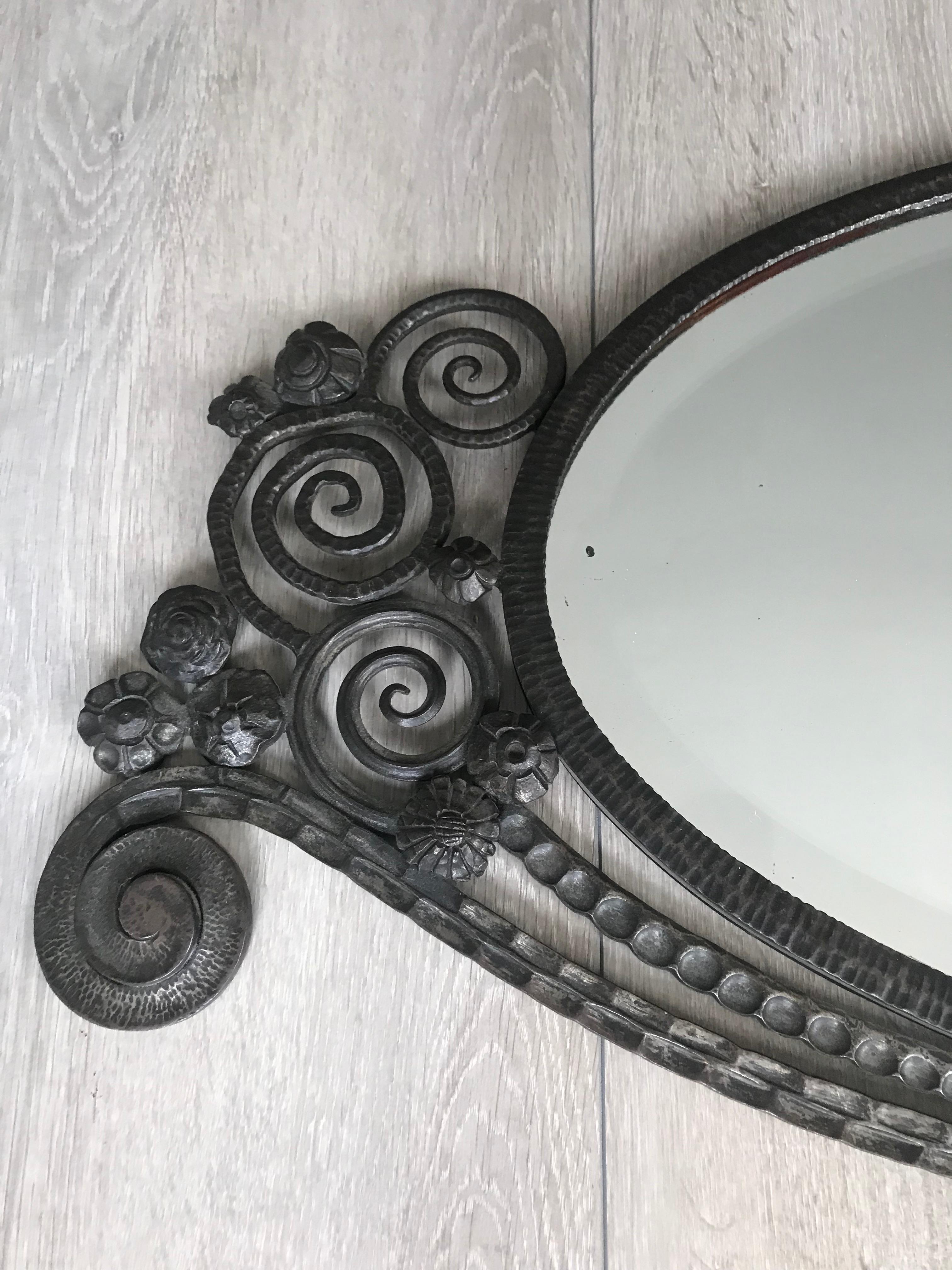 Rare and stunning Art Deco mirror, possibly by Edgar Brandt.

This oval shape and beveled mirror comes with the original French Art Deco Mirror frame. The quality of both the design and the workmanship that was put into creating this hand forged,