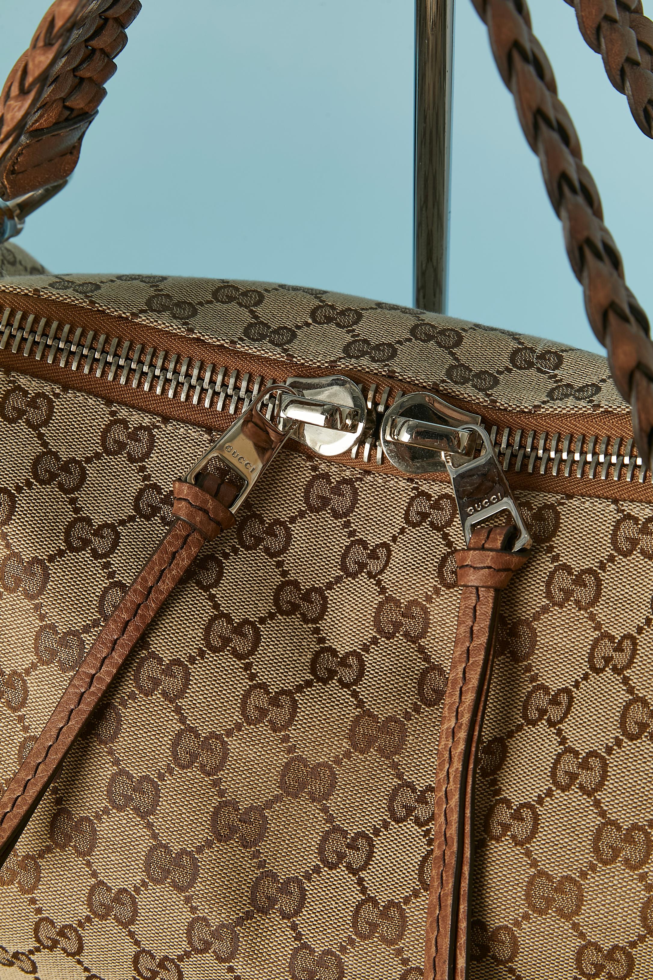 Sac à bandoulière en canevas monogramme et poignée supérieure en cuir, quincaillerie en métal argenté et bambou. 
TAILLE : 33cm (hauteur) X 40cm (longueur) X 15cm (profondeur)
Longueur de la poignée en cuir : 56cm 
Fermeture à glissière sur le