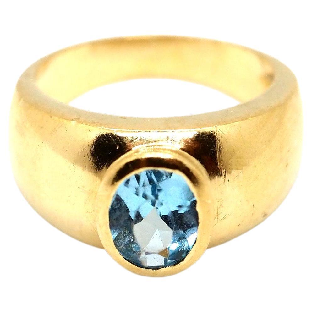 A solid and elegant ring crafted in massif 18 Karat yellow gold. 
This ring features a beautiful, high-quality blue topaz gemstone set in a sturdy, yet elegant gold band. 
The blue topaz gemstone is a vibrant shade of blue, with a smooth and