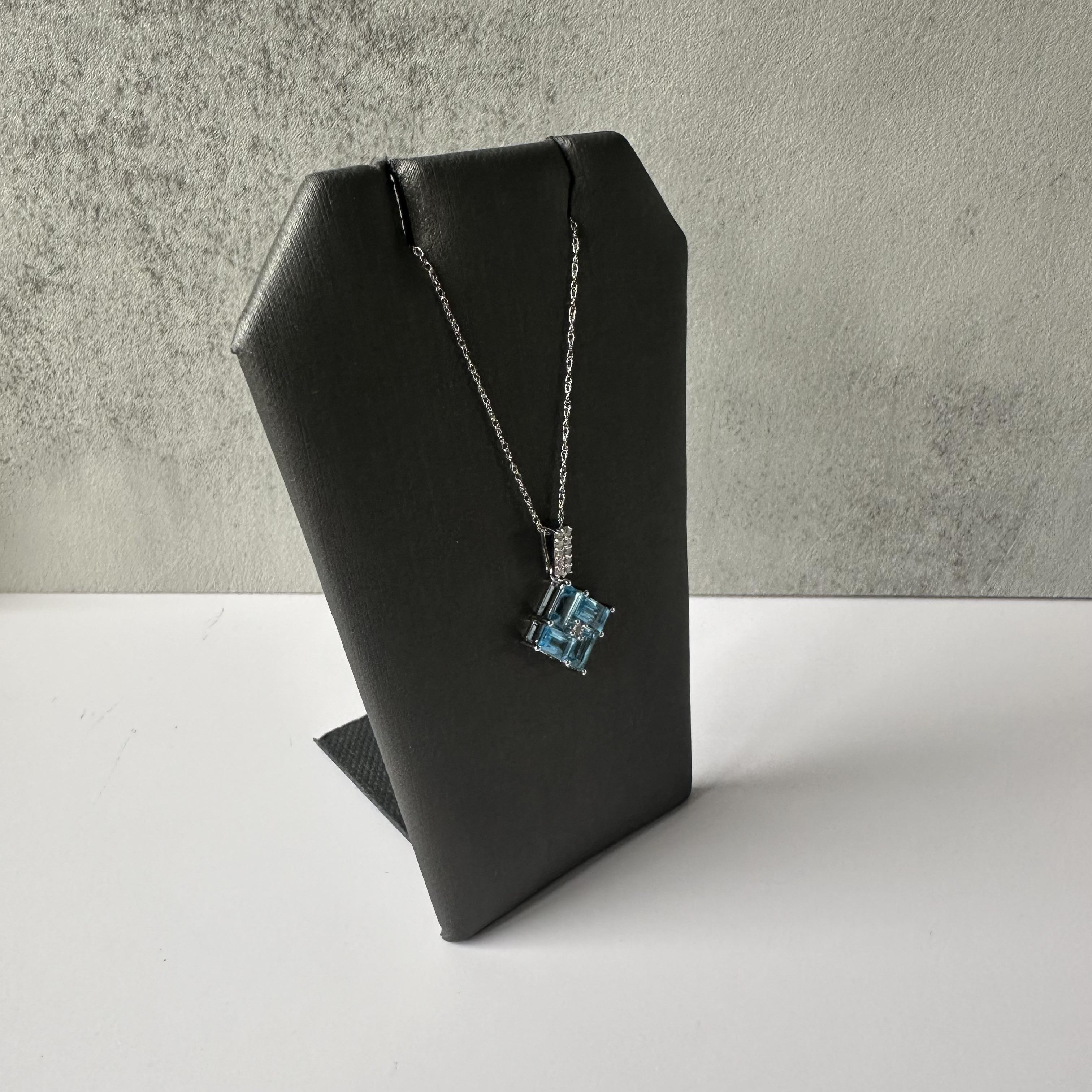 This elegant Topaz and Diamond Necklace in 10kt White Gold features four beautiful blue topaz stones that radiate a serene blue hue. Accented with sparkling natural diamonds, this piece is perfect for any occasion, bringing sophistication and grace