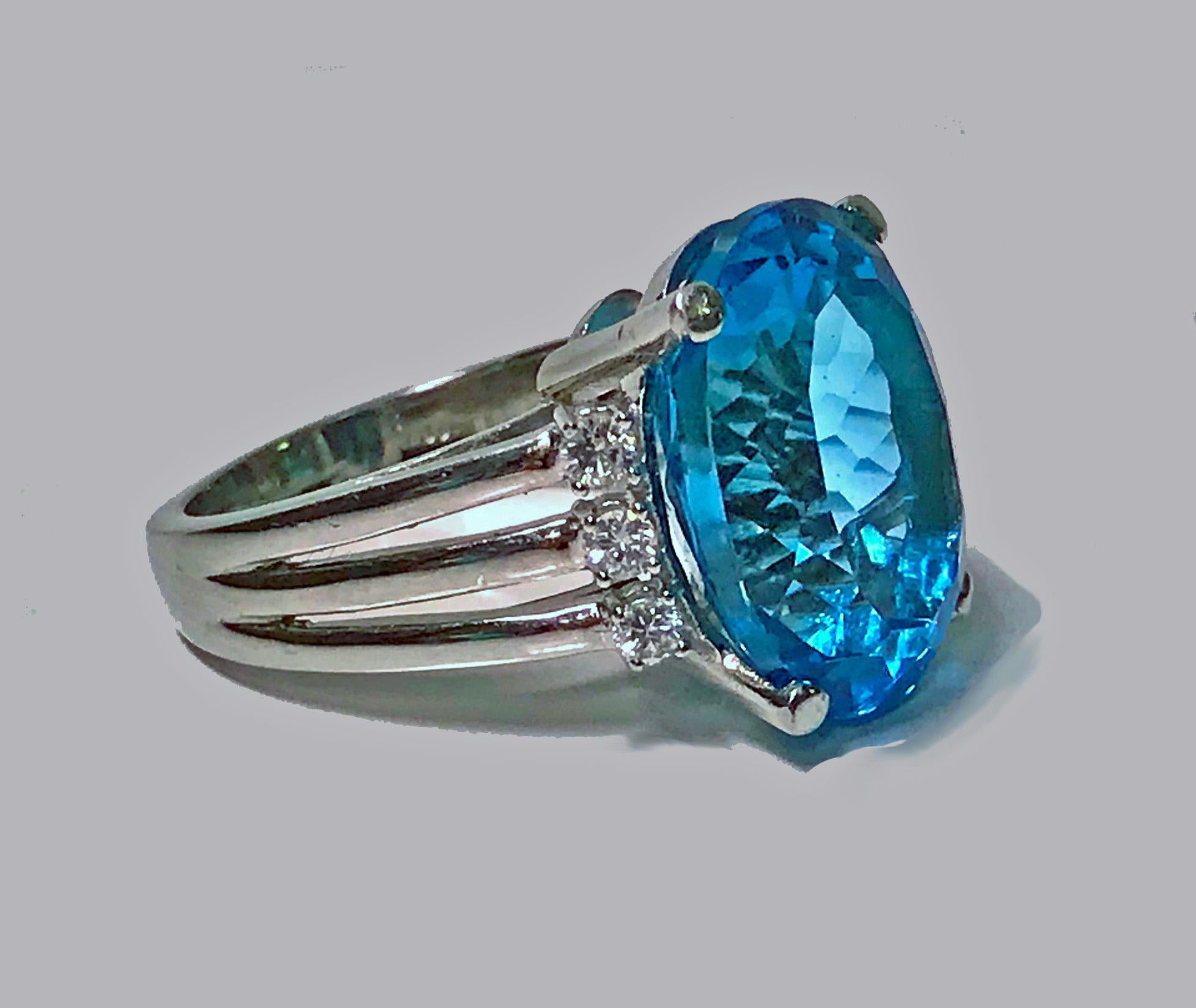 Topaz and Diamond Ring, 20th century. The Ring set with an oval facetted dark tone, very strong intensity blue topaz, gauging 15.95 x 12.00 x 9.00 mm, 13.50 cts, VVS clarity (type 1), flanked with six round brilliant cut diamonds, approximately 0.30