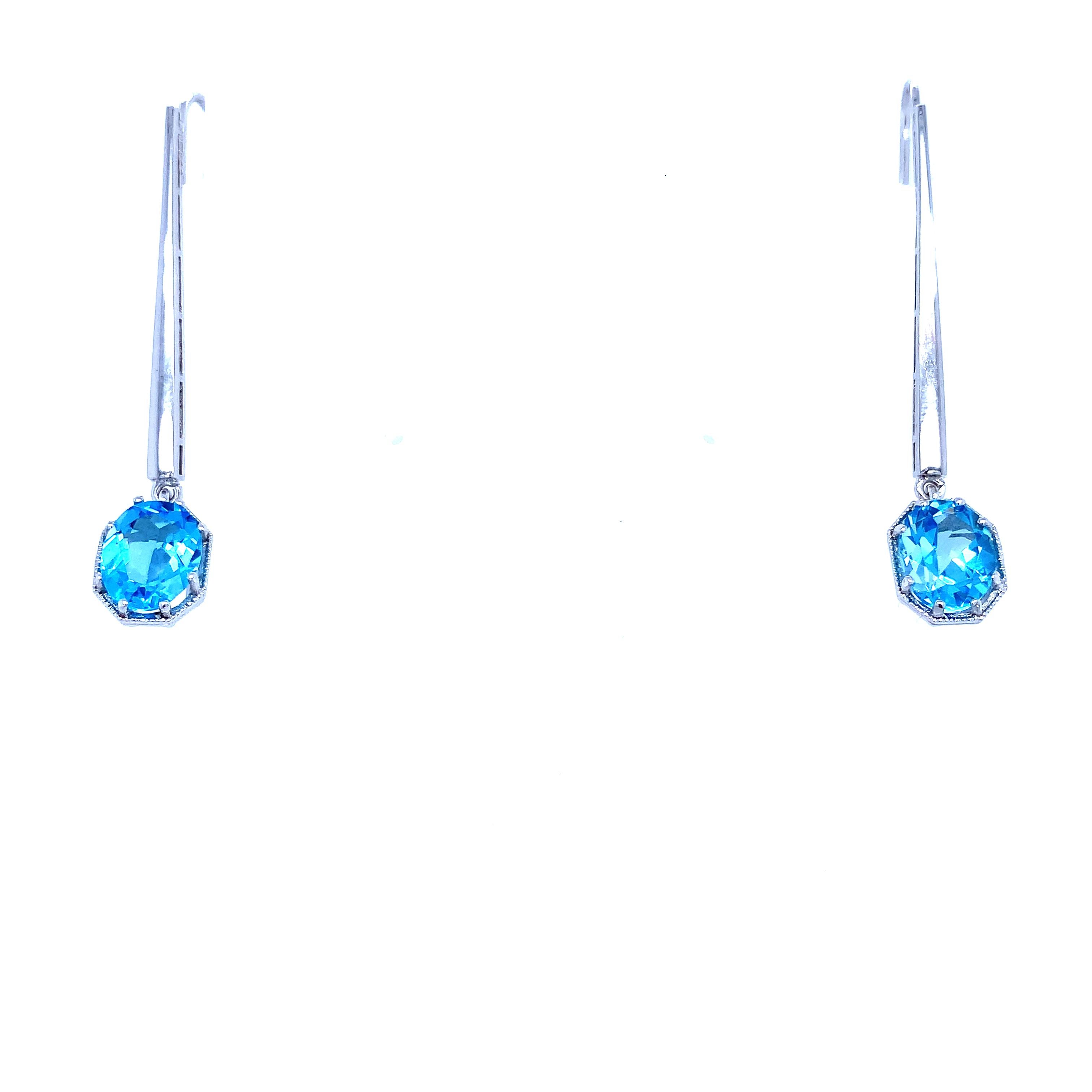 Embrace the glamour of the Art Deco era with these stunning drop earrings. Crafted from 18k white gold, they feature a beautiful 2.50ct blue topaz that dazzles under the light. The milgrain setting style enhances the elegance of the design, while