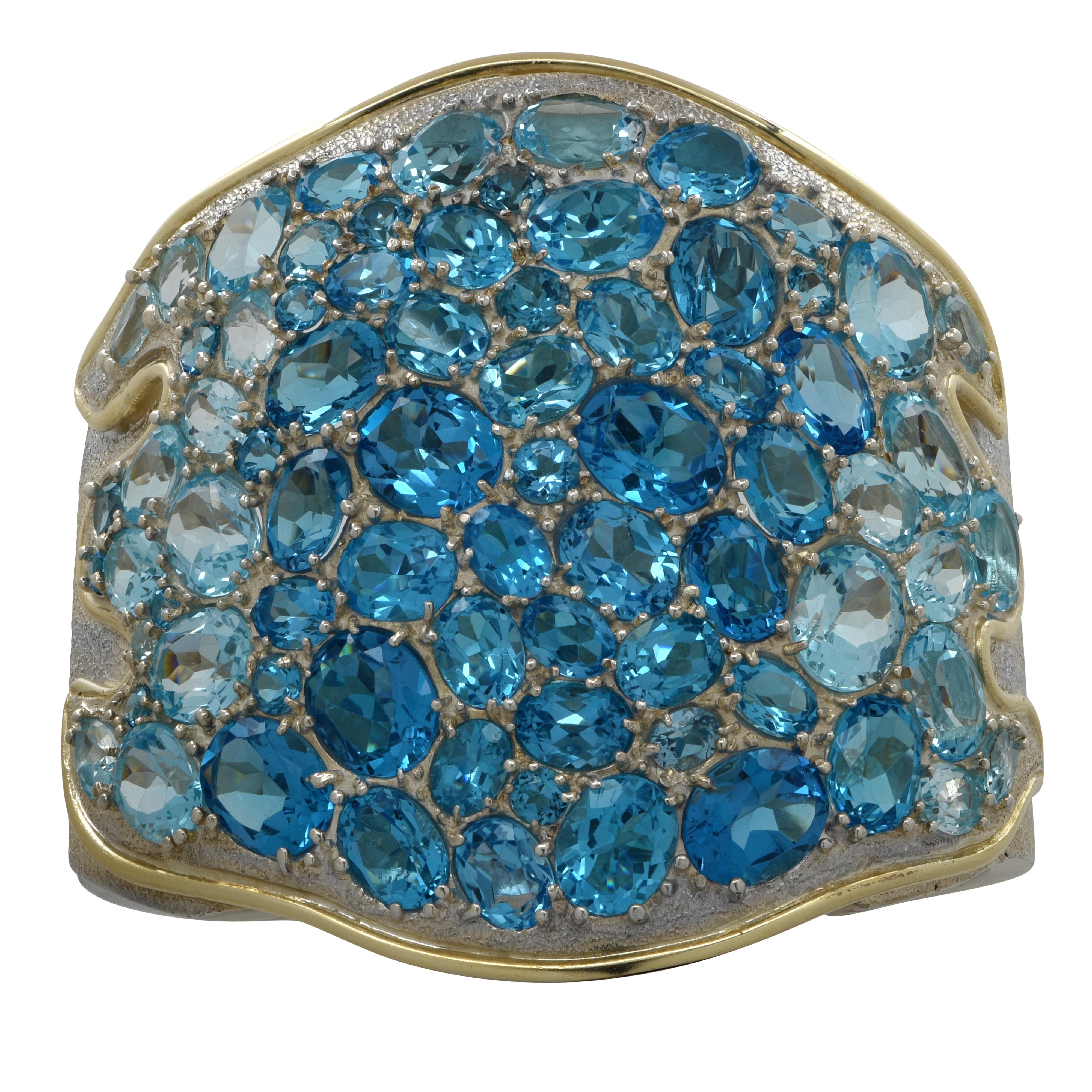 Auffällige Armspange aus Silber mit 73 ovalen Blautopas-Steinen. Dieses wunderschöne Armband misst 2,7 Zoll an seiner breitesten Stelle und verjüngt sich auf 0,8 Zoll. Dieses Armband  Es wiegt 175.3 Gramm. Dieses besondere Stück ist eine