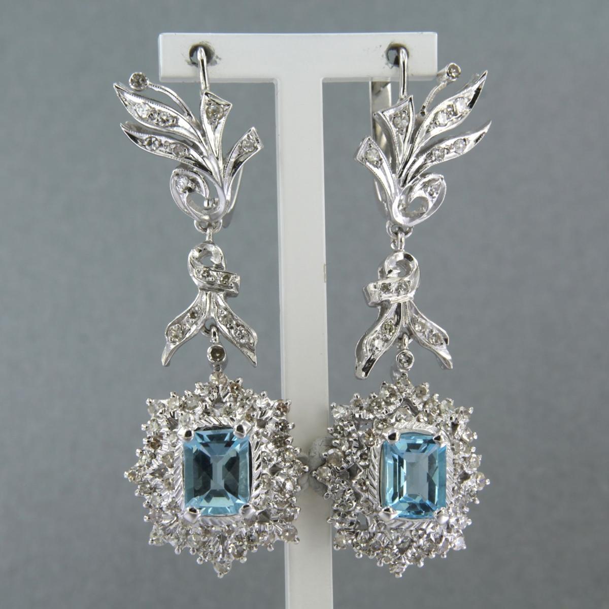 Topaz Diamond 14k White Gold Chandelier Earrings
Shining blue topaz 5.00 carat with diamonds 3.24 carat set in white gold.

Dimensions : (height x width) 5.7 cm x 2.7 cm
Weight : 20.8 gram

Set with:
- 2 x 9,0 mm x 7,0 mm emerald cut blue topaz,