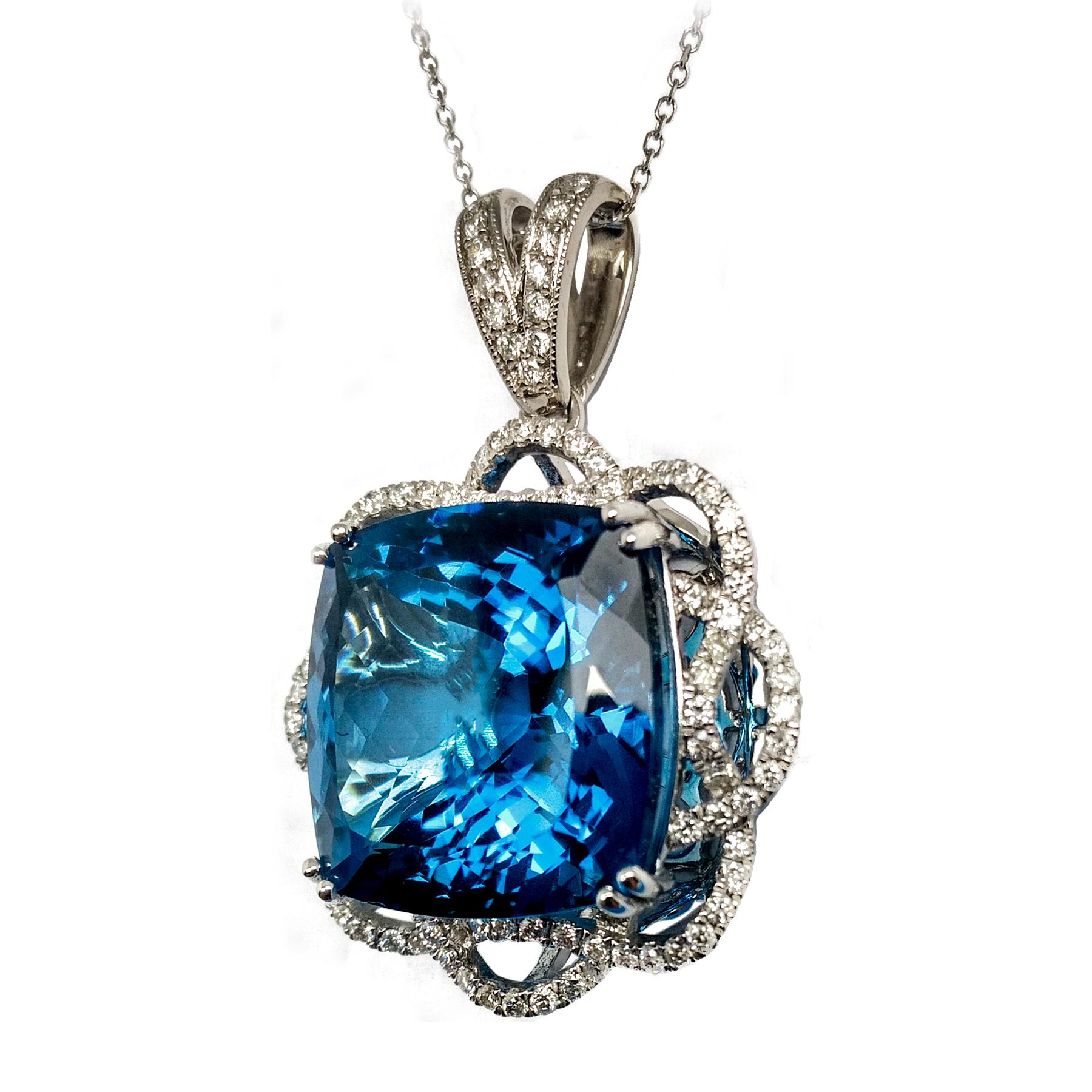 Intense sky blue 23.71 carats topaz and diamond pendant. Contemporary handcrafted cushion faceted, high luster topaz mounted in high profile basket with 4 prongs, accented in round brilliant diamond swirl design in 14 karat white gold, along with 10