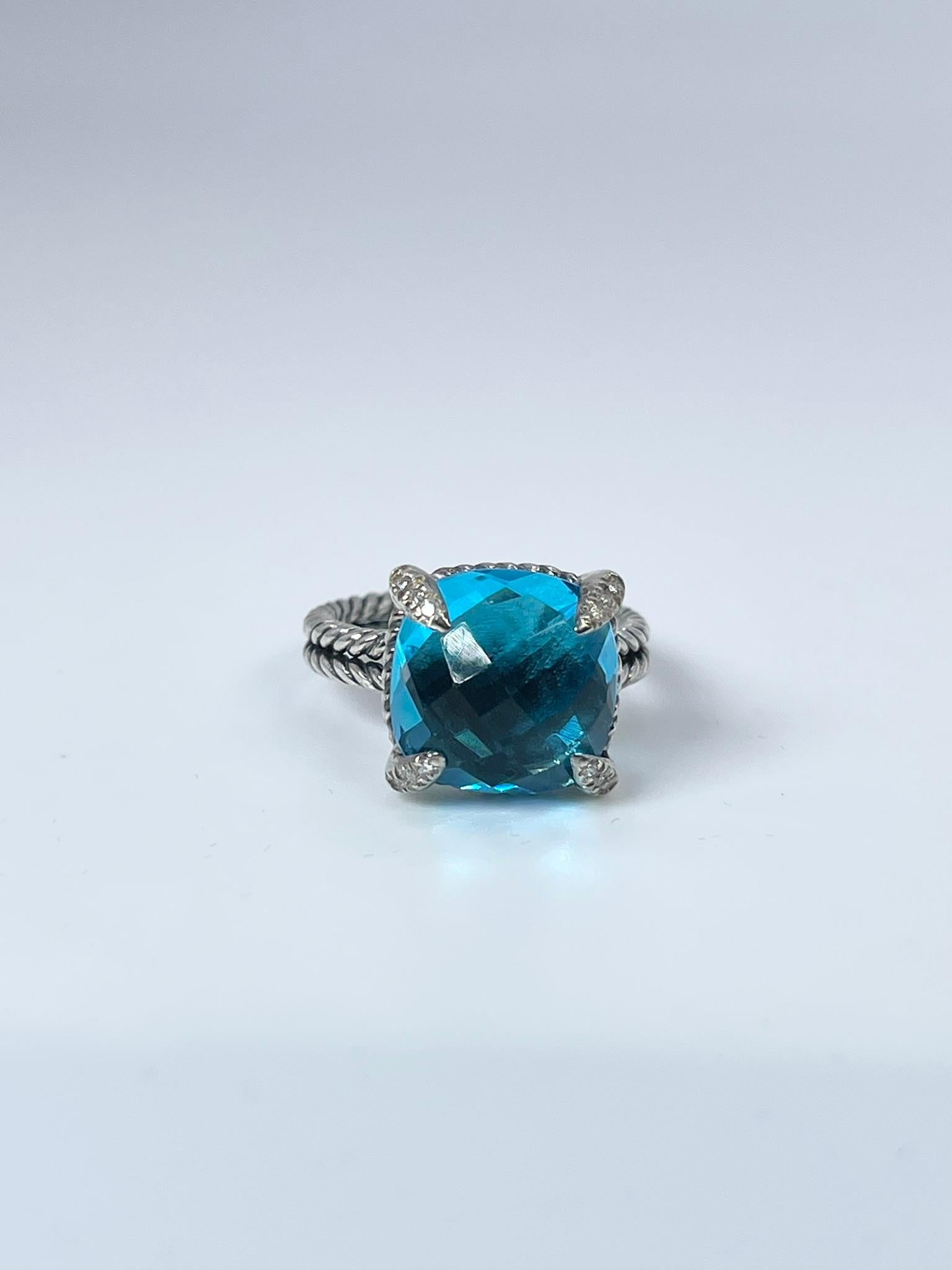 Silver ring by David Yurman with natural topaz and diamonds.

GRAM WEIGHT: 5.81gr
METAL: silver 925

NATURAL DIAMOND(S)
Cut: Round Brilliant
Color: G-H 
Clarity: SI (average)
Carat: 0.10ct

NATURAL TOPAZ
Cut: Cushion Checkered
Color: Blue