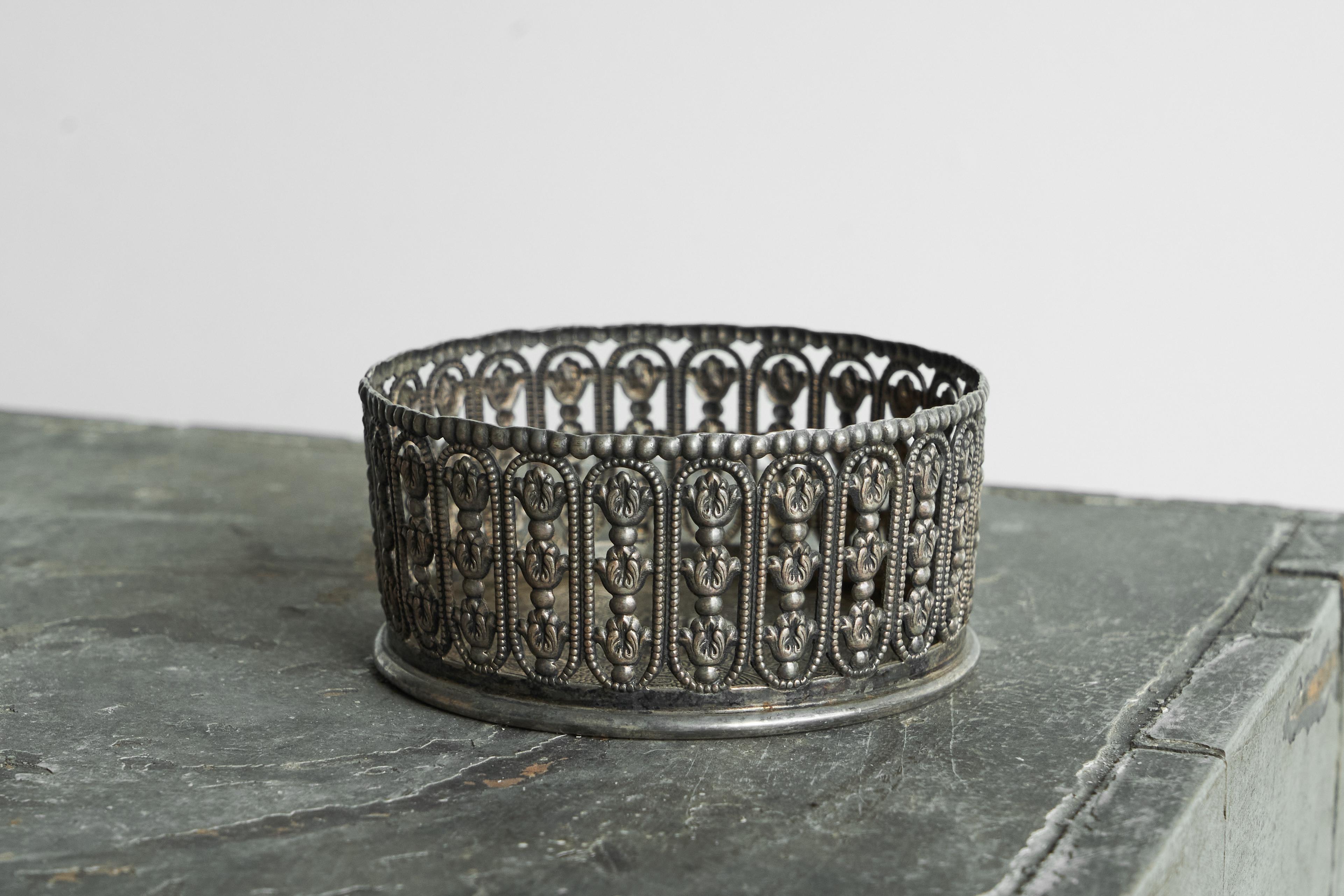 Portabotellas de vino Topazio Casquinha en chapa de plata, Portugal, principios del siglo XX.

Se trata de un portabotellas (de vino) muy decorativo con una rica e intrincada decoración, realizado en chapa de plata y que data de principios del siglo
