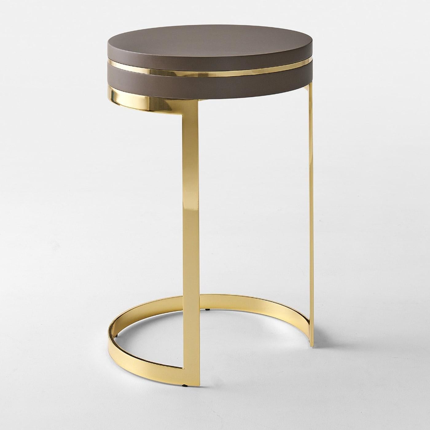 Distinctly modern in its asymmetrical design and rich in geometric lines, this round side table makes for a refined addition to modern interiors. A precious glossy golden finish marks the sleek structure, which comes complete with wooden inserts