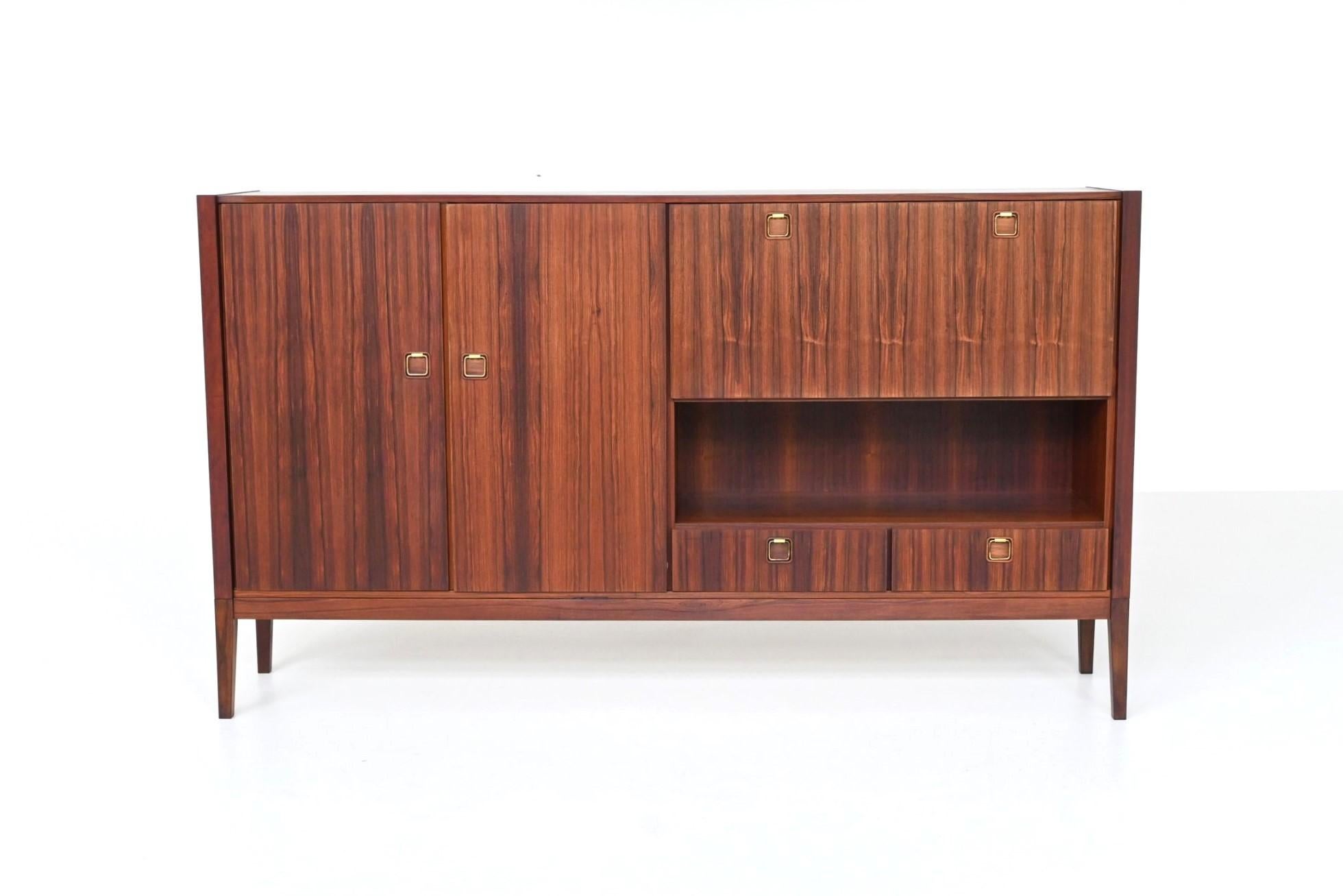 Beautiful highboard or sideboard manufactured by Topform, The Netherlands 1960. This very nice slim shaped highboard is made of beautifully grained veneered rosewood with solid legs. Even the inside door panels are beautiful flamed. It has two doors