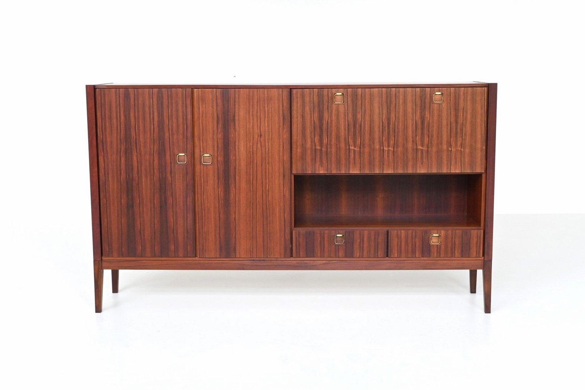 Beautiful highboard or sideboard manufactured by Topform, The Netherlands 1960. This very nice slim shaped highboard is made of beautifully grained veneered rosewood with solid legs. Even the inside door panels are beautiful flamed. It has two doors
