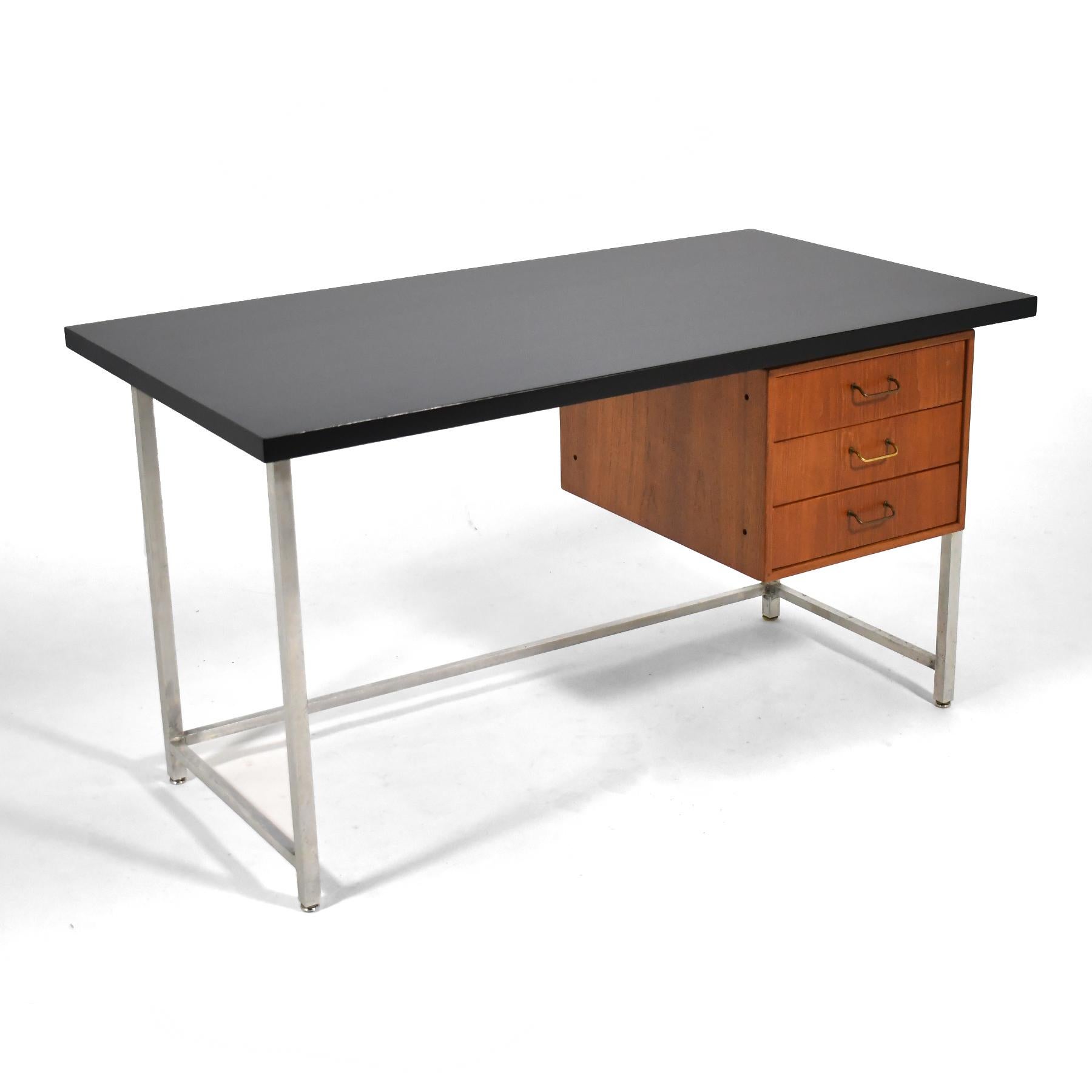 This beautiful Danish modern writing desk by Torben Strandgaard is finely crafted by Møbelfabriken Falster and beautifully detailed with an architectural aluminum frame, floating cabinet with brass wire pulls on the three drawers. The case is
