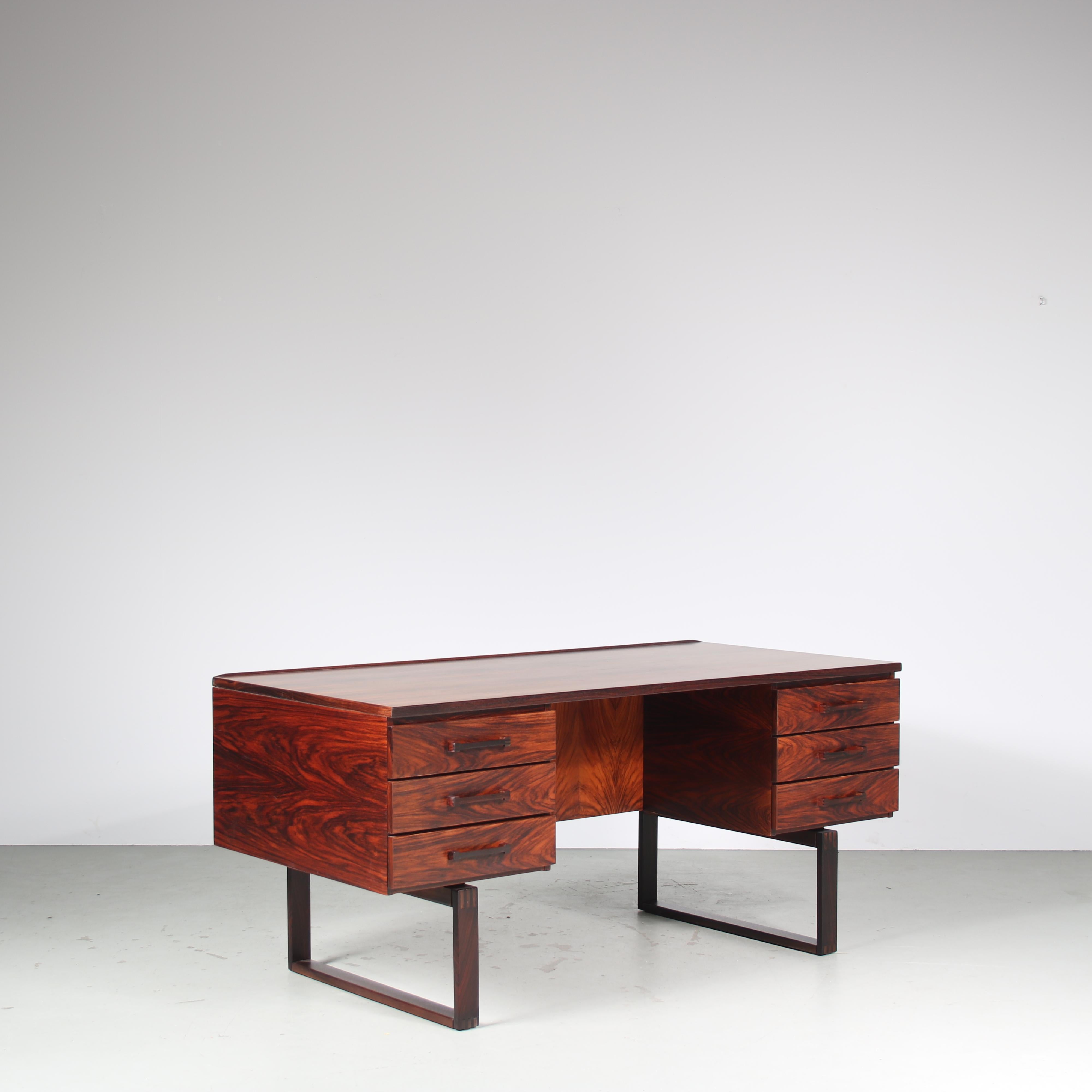 A fantastic desk designed by Torben Valeur & Henning Jensen, manufactured by Munch Mobler in Denmark around 1960.

This impressive desk is made of the highest quality tropical hardwood in a truly beautiful deep brown colour. Standing on two