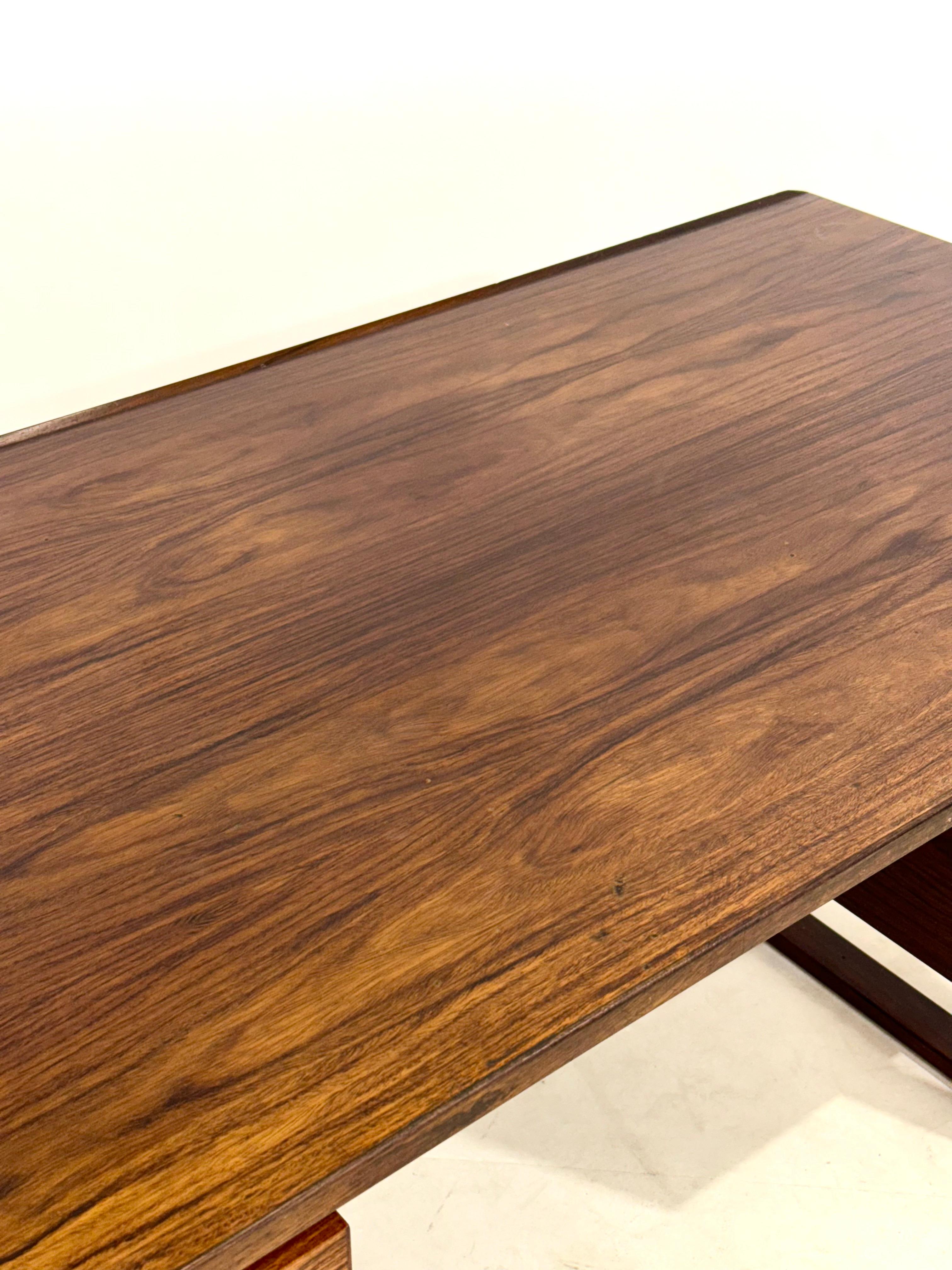 A fantastic rosewood desk designed by Henning Jensen & Torben Valeur manufactured by Munch Mobler in Denmark around 1960.

Standing on two rectangular legs with beautiful  On both sides the piece has three drawer units with rectangular handles in a