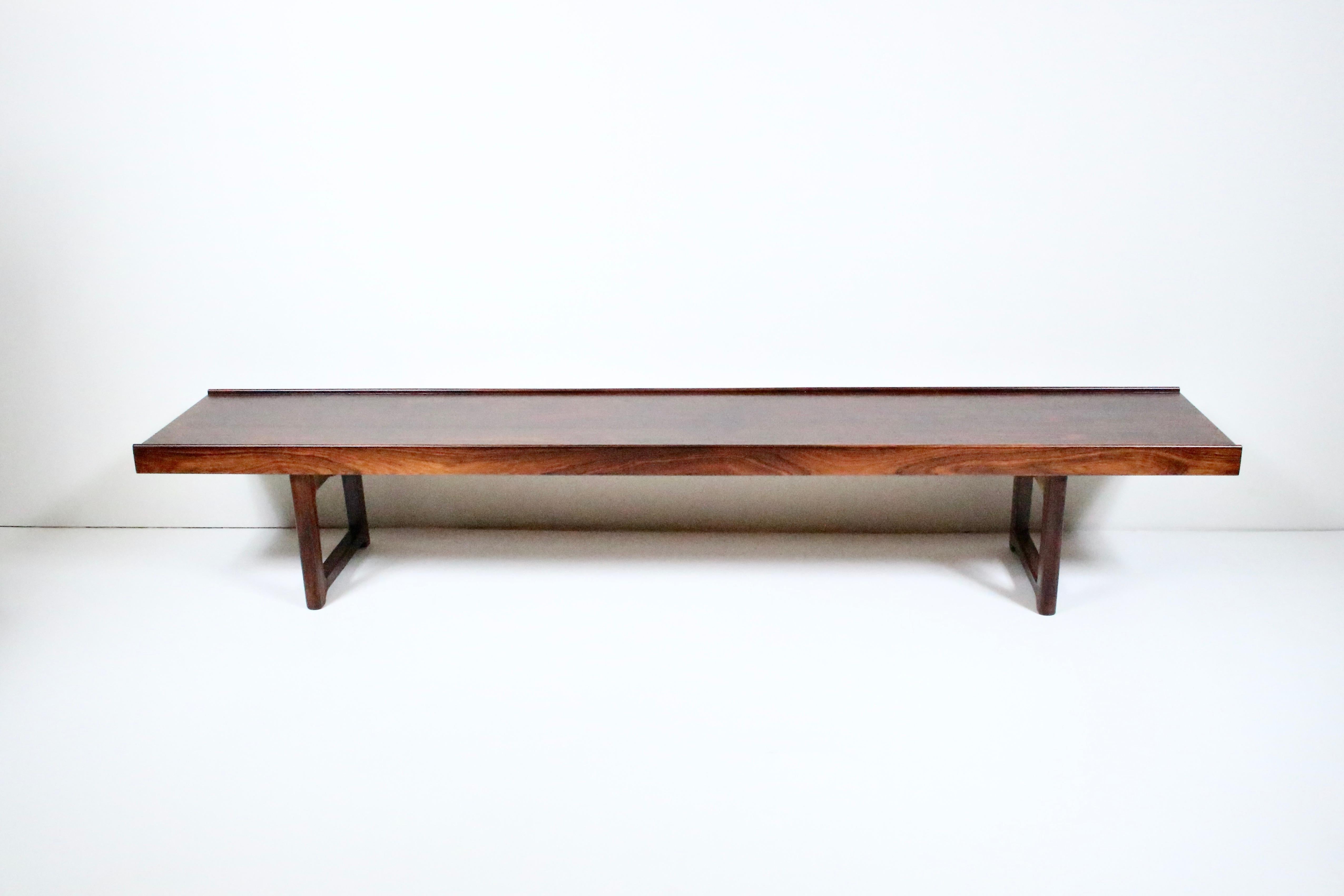 Table en palissandre massif de Torbjorn Afdal, banc de Bruksbo Mellenstrands Norvège. Ce meuble présente un cadre rectangulaire robuste et équilibré en bois de rose foncé au grain lisse, avec des pieds soutenus par de l'acier. Polyvalent. The Modern