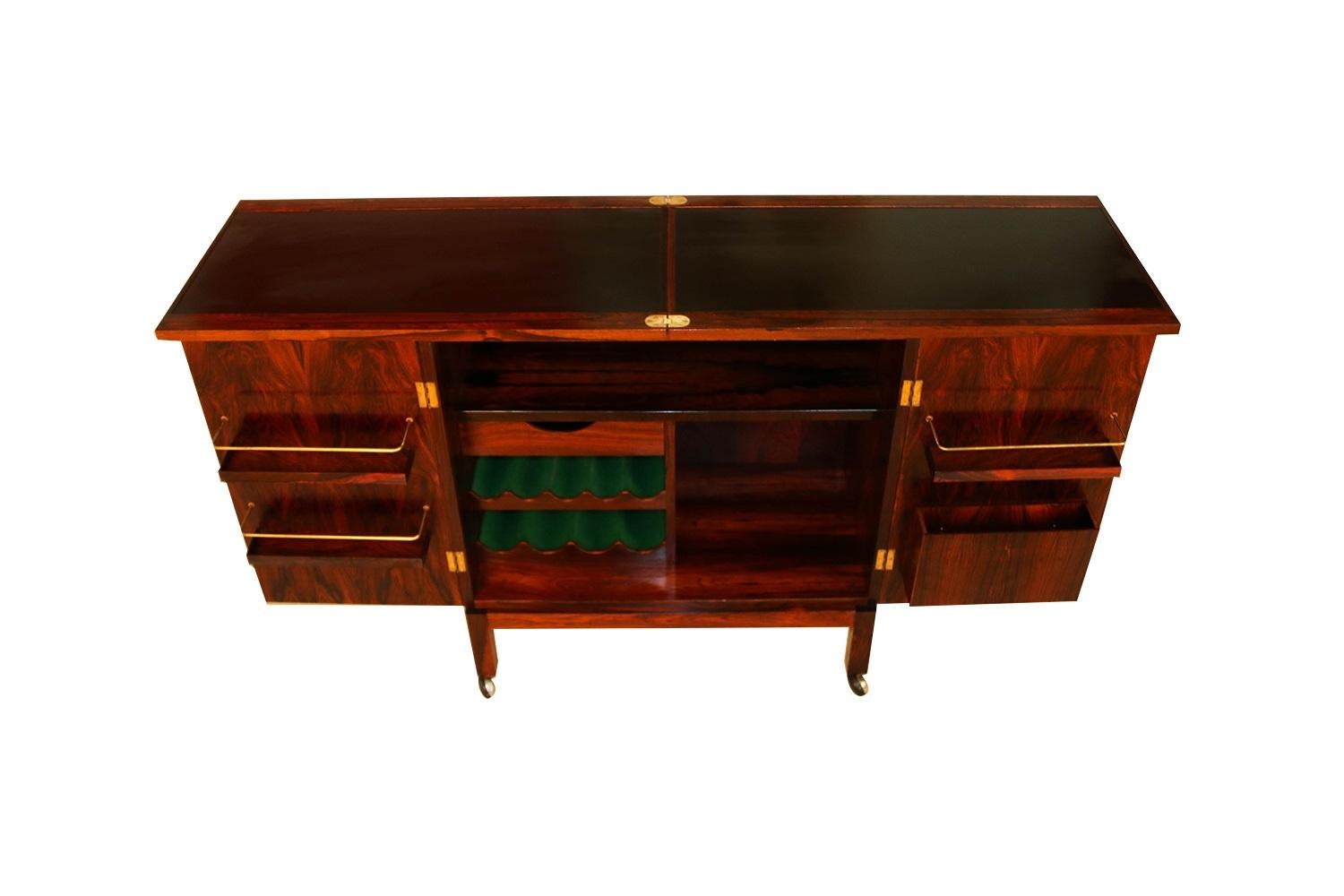 Absolutely beautiful and functional Mid-Century Modern “flip top” rosewood, bar cabinet/ cart by Torbjorn Afdal for Mellemstrands Møbelfabrik / Bruksbo of Norway, circa 1960s. Makers stamp (Furniture Control Norway Mobelfakta} on the underside of