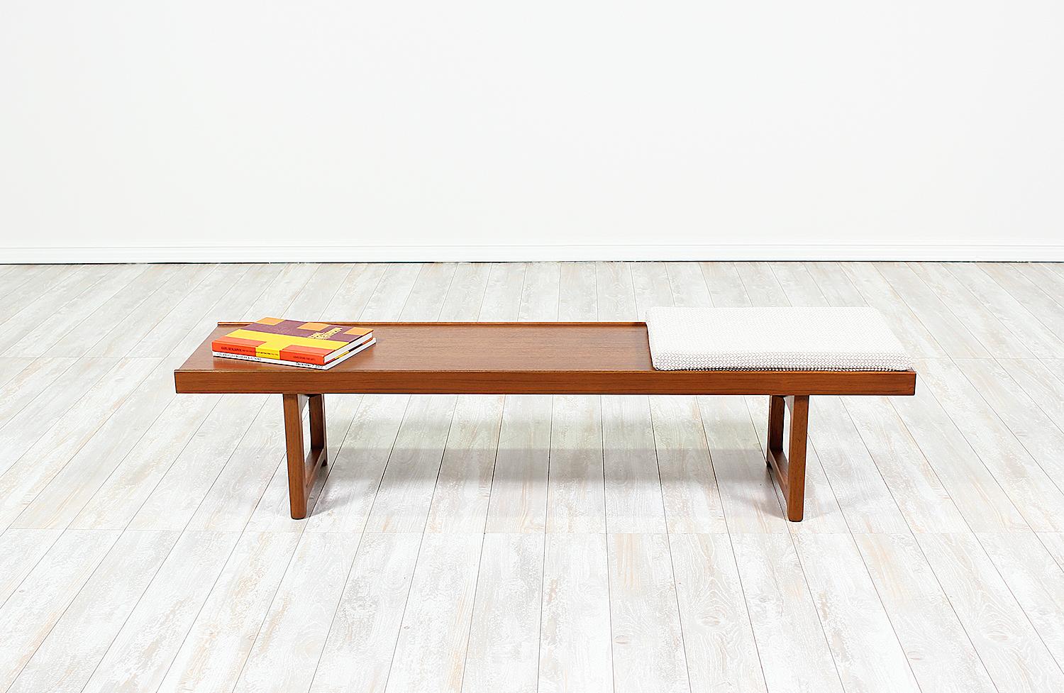 Bench or coffee table designed by Torbjørn Afdal for Bruksbo in Norway circa 1960s. A versatile and playful design featuring a beautiful and distinct teak wood grain over the rectangular, raised lip top and supported by sculpted geometric legs. Its
