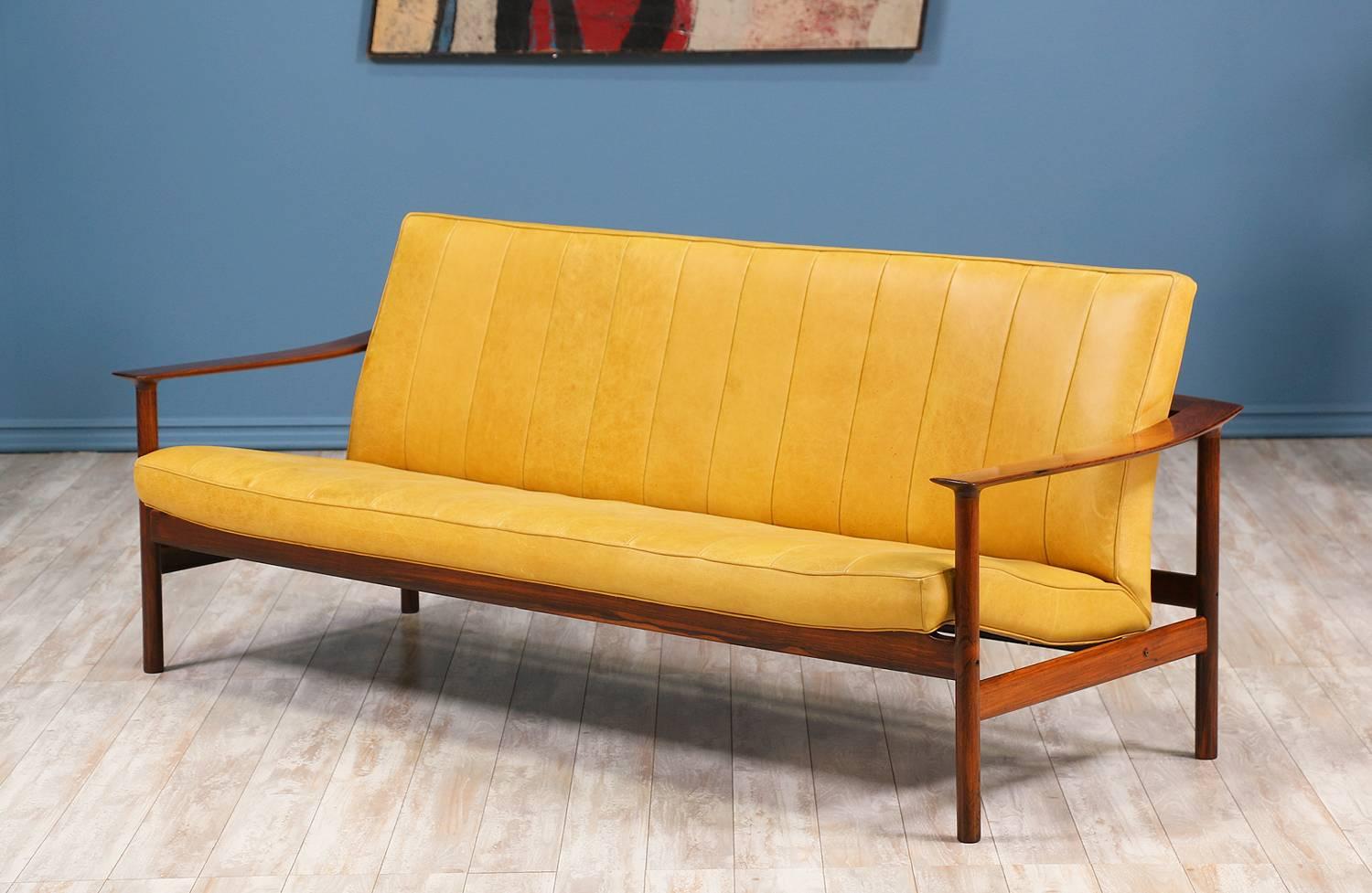 Norwegian modern sofa designed by Torbjørn Afdal for Svein Bjørneng circa 1960’s. With a vibrant mustard yellow leather seat founded on a newly refinished Brazilian rosewood frame, this expertly crafted design has been reupholstered with new