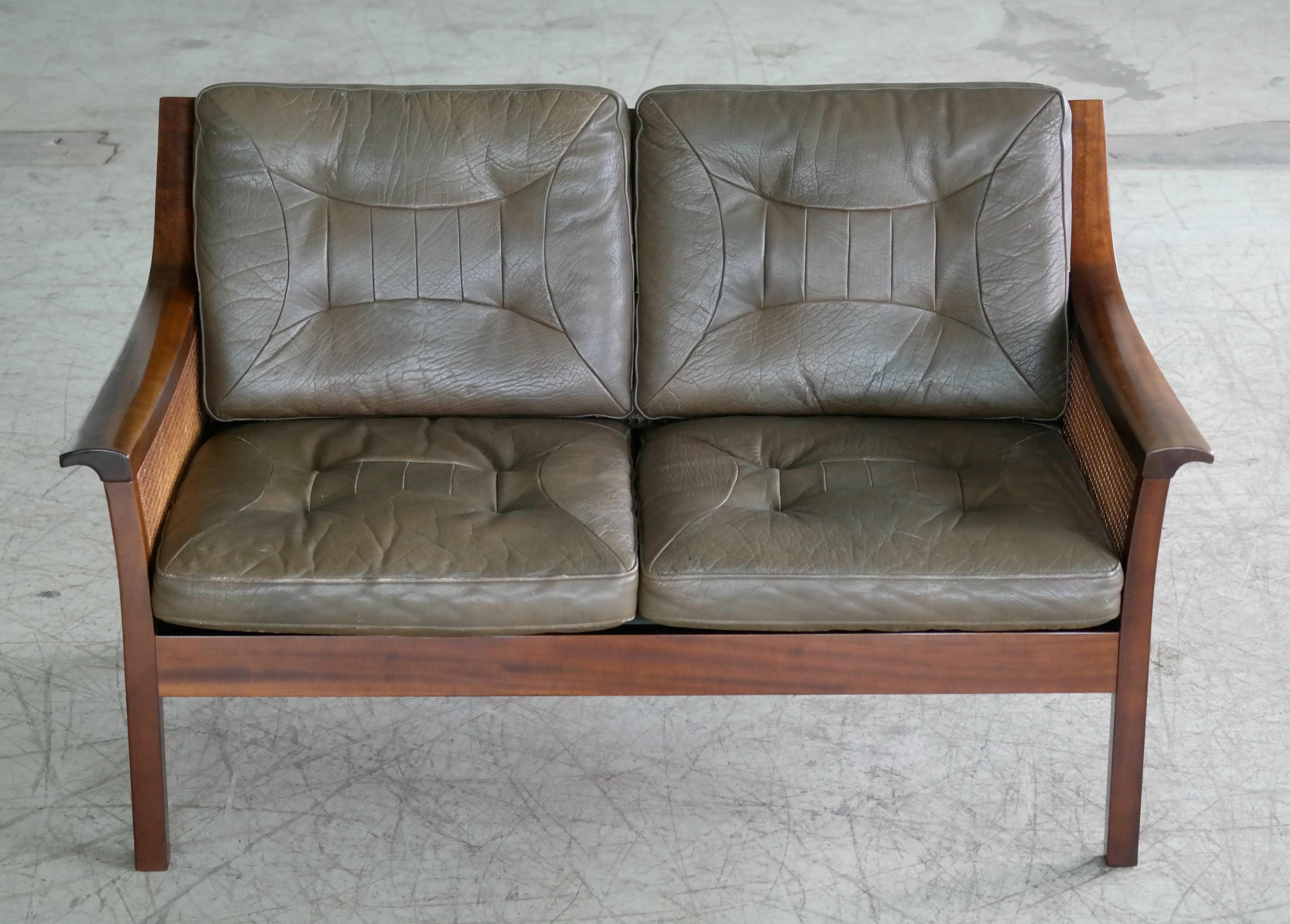 Beautiful Torbjorn Afdal designed sofa in stained beech with top grain olive colored leather cushions and woven double sided cane in the back and sides. Both cane, wood and leather show great patina throughout with only minor age appropriate wear