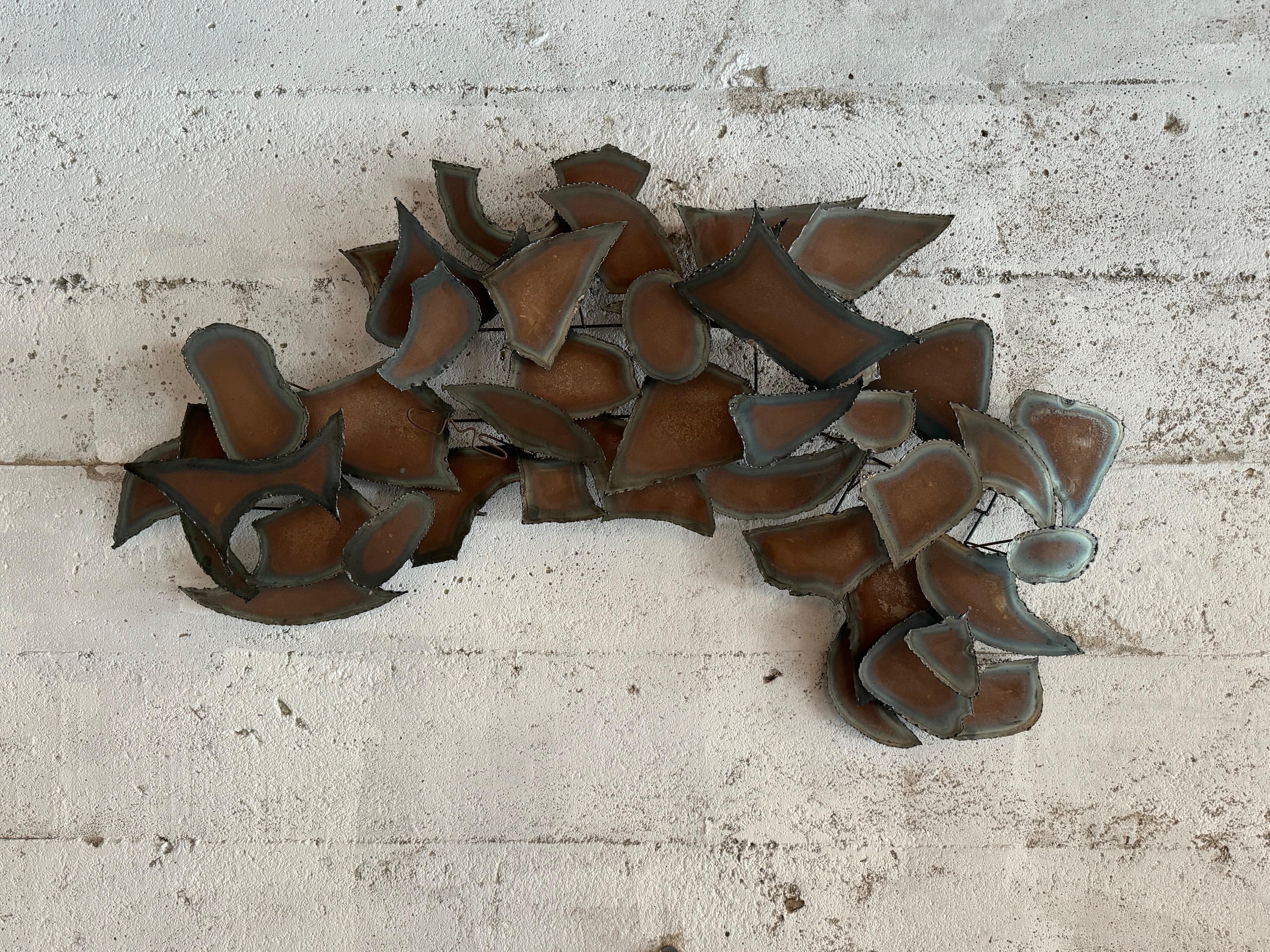 Torch cut abstract wall sculpture in the Brutalist aesthetic circa 1970s. Various torch cut abstract forms arranged in a flowing pattern held together by a network of wire rods. The artists signature was done in wire 