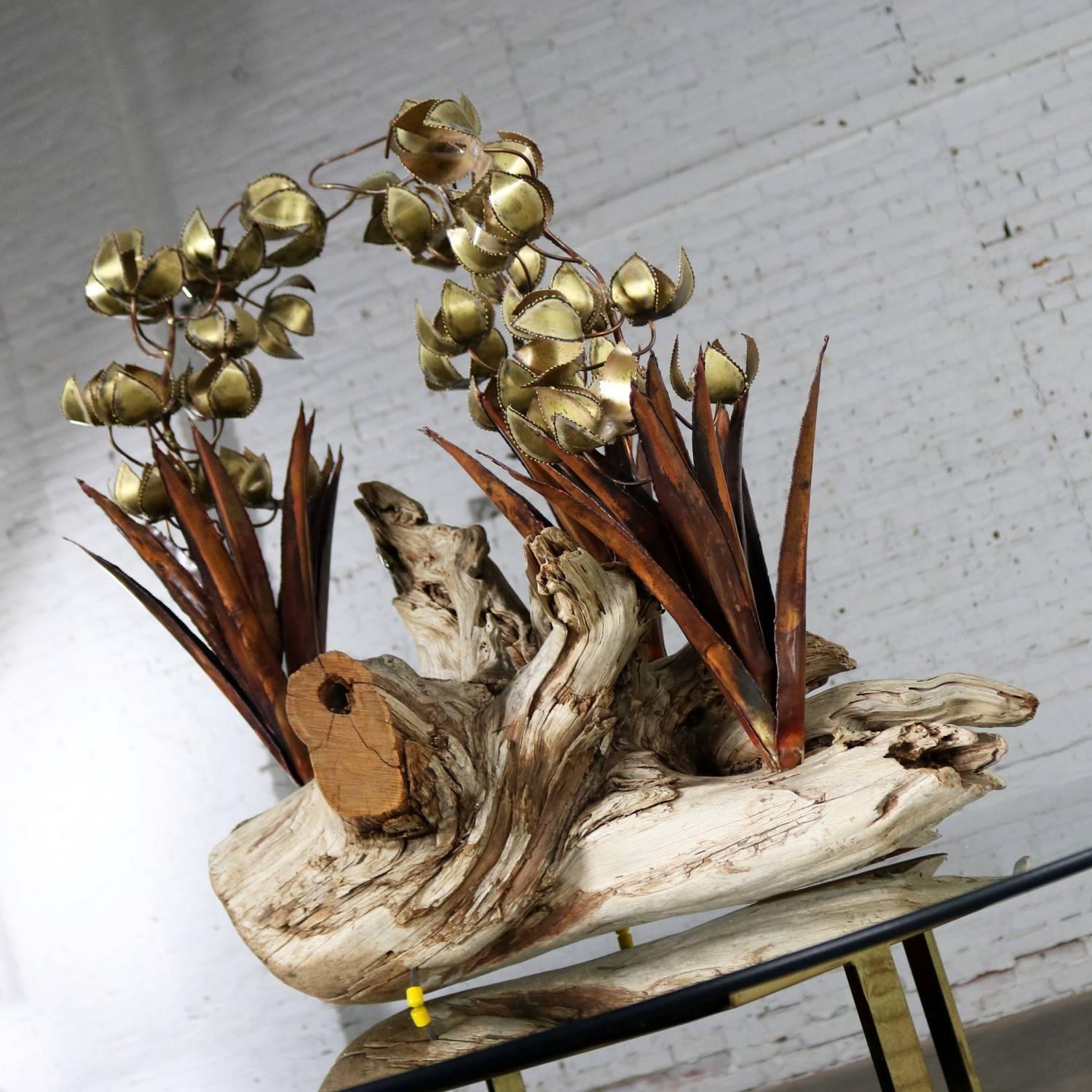 Incredible Brutalist torch cut copper and brass floral sculpture on driftwood. Unsigned but done in the style of Silas Seandel or C. Jere. It is in excellent vintage condition, circa 1970s.

This is the most stunning floral sculpture I believe I