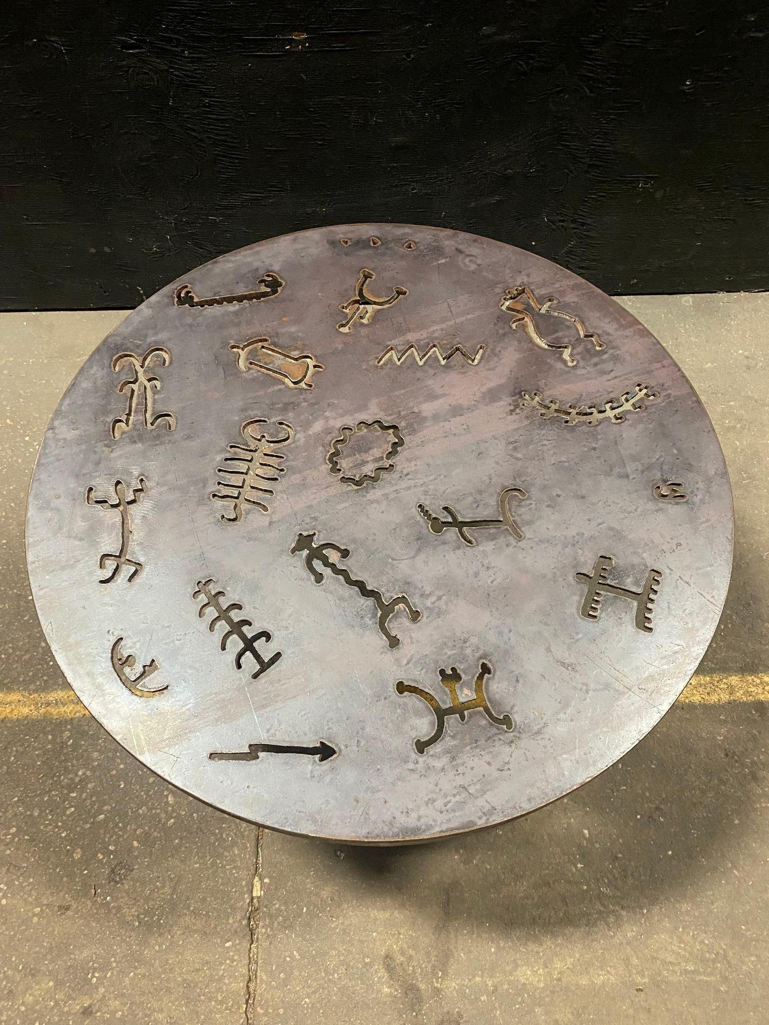 This is a beautiful Vintage Torch Cut Iron table in the brutalist style. it features intricate torch work depicting primitive glyphs. This is a potent piece of furniture that would add grates to any environment. it measures 32