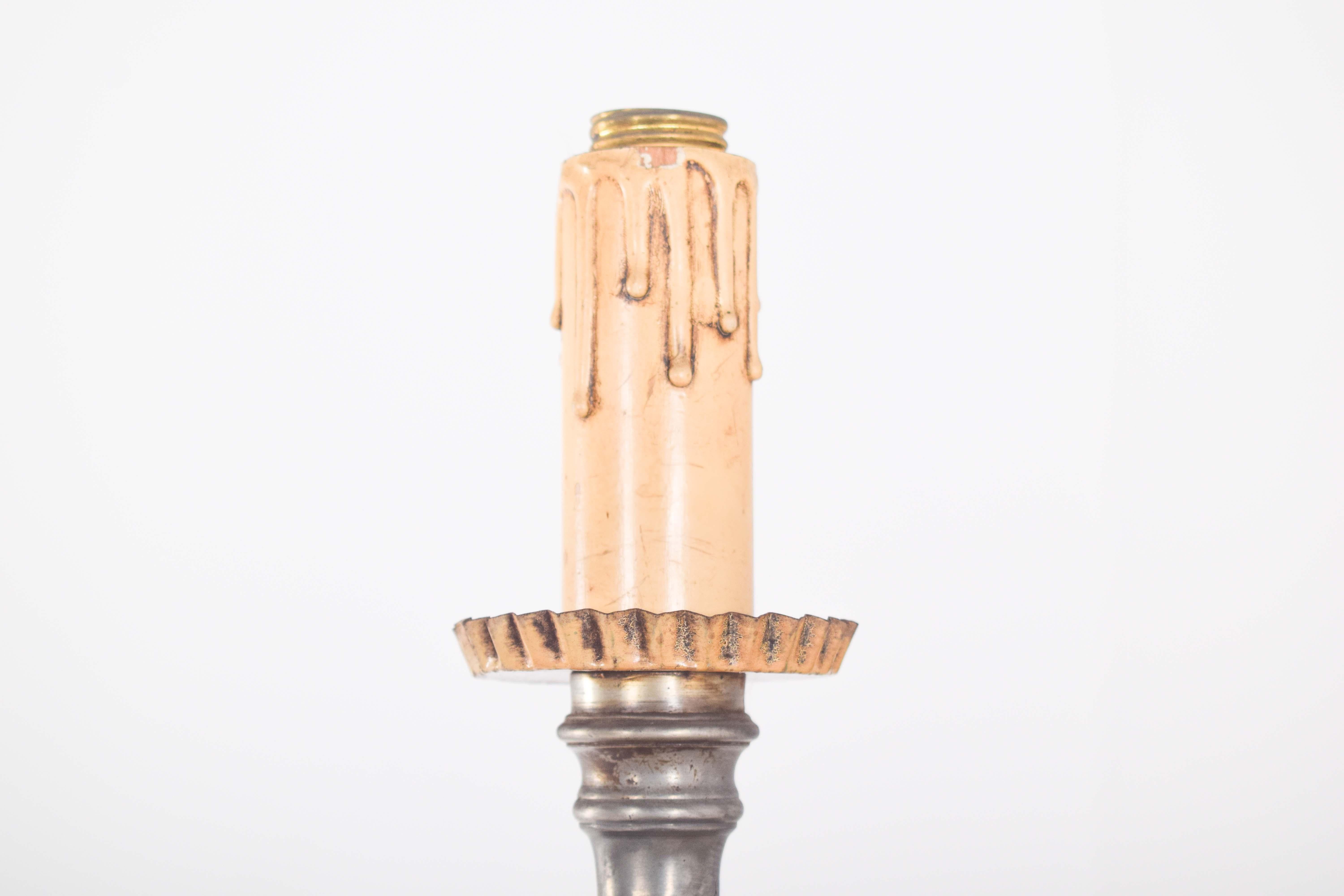Torch holder in turned tin, electrified. With a tall, slender structure, the torch holder has an ornate base, with sculpted details that give sophistication to the piece. The solid square base ensures stability, while the openwork decorative