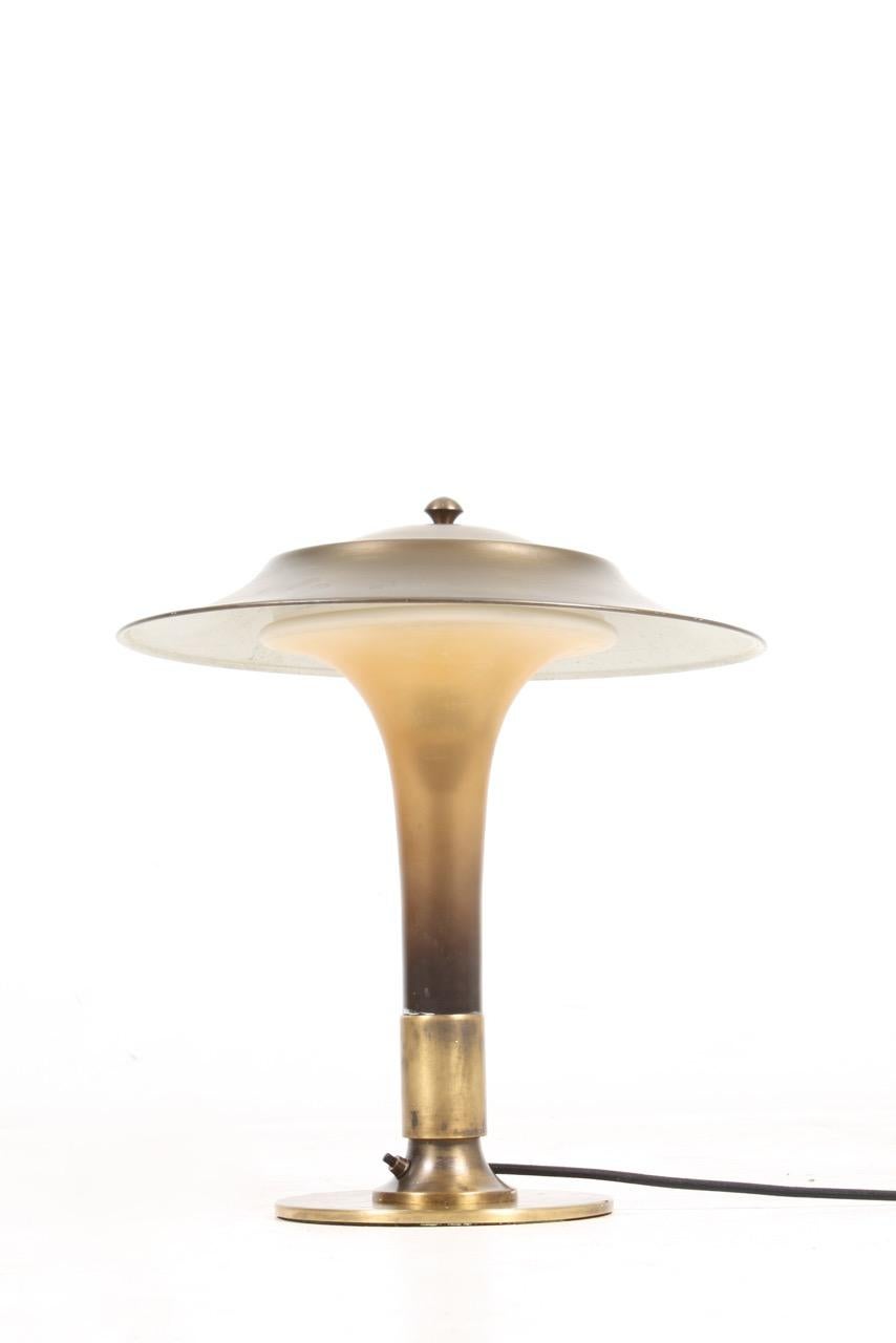 Art Deco table lamp in patinated brass and glass. Made in Denmark in the 1930s.