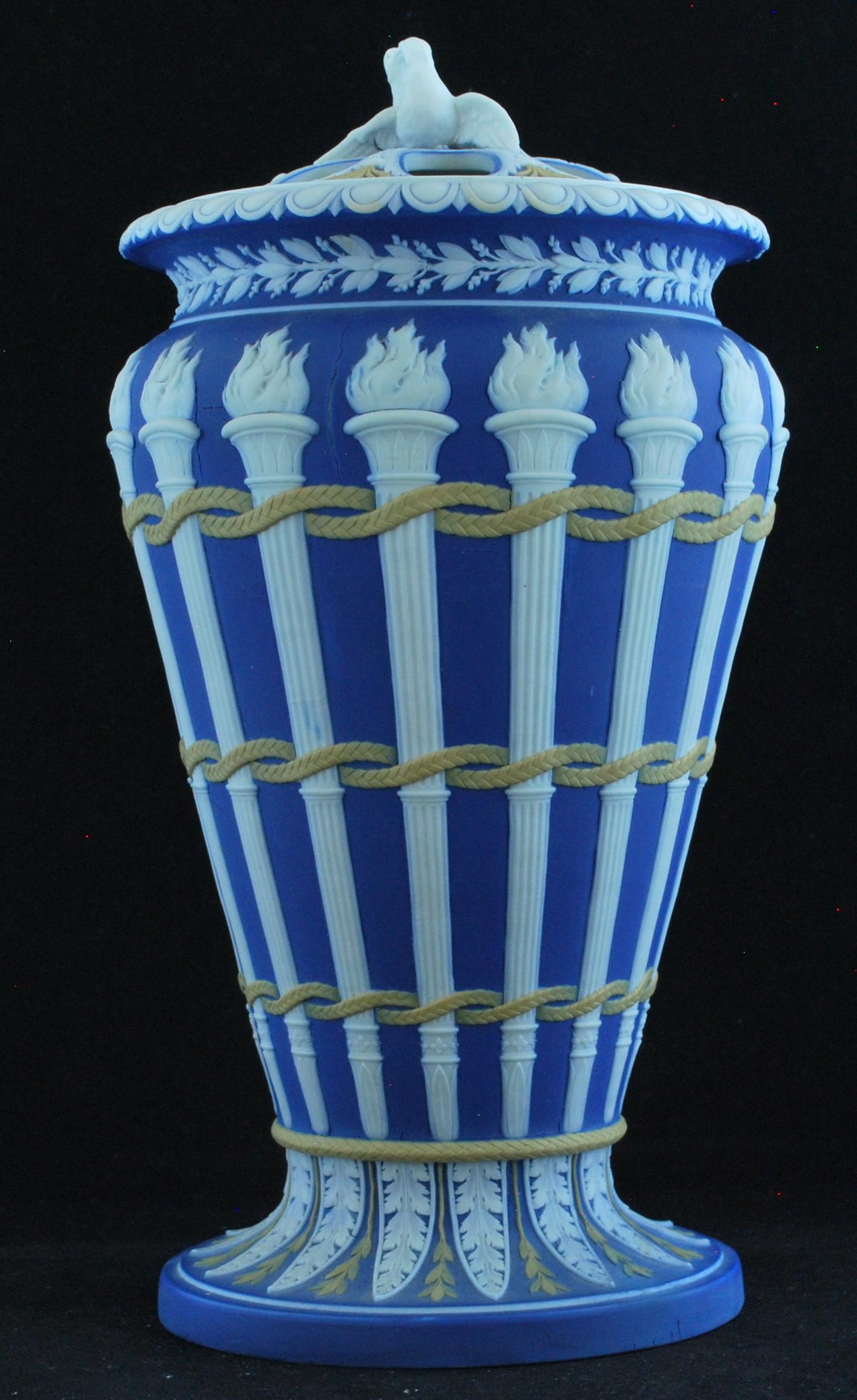 A very tall and very striking tricolor torch vase, complete with cover.

In neoclassical iconography, the torches symbolize marriage; hence the love-bird finial.
 